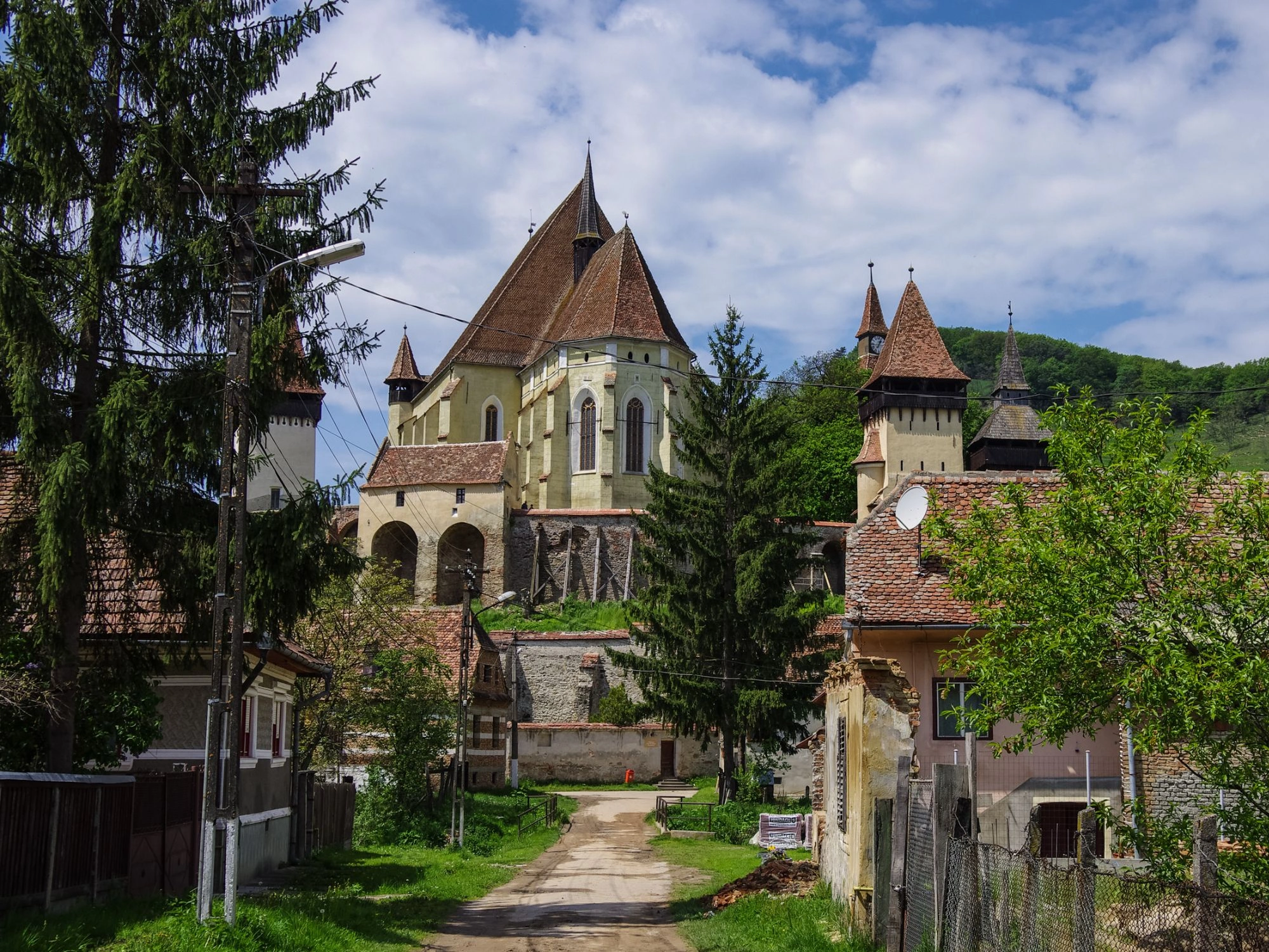 Biertan fortified church surrounded by old Saxon houses and greenery in Transylvania