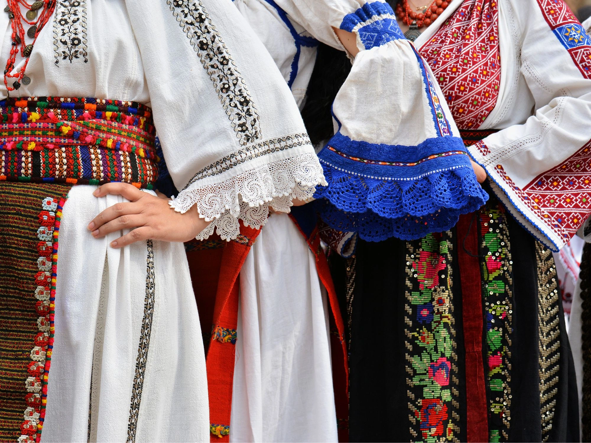 Traditional Romanian folk costumes with colorful embroidery, lace, and intricate patterns.