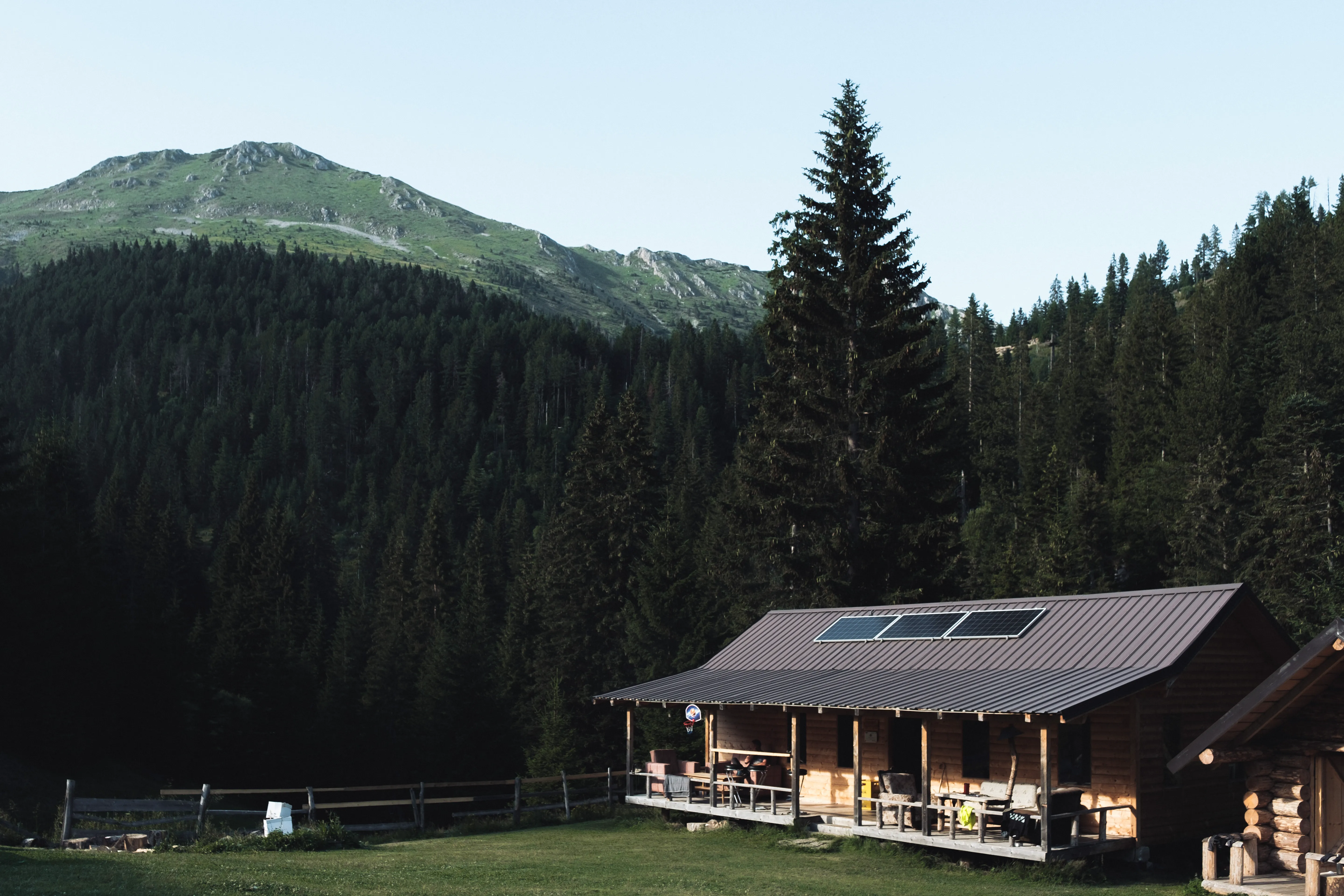 Rustic wooden guesthouse in Milisevc, surrounded by pine forest and mountain views on the Via Dinarica trail