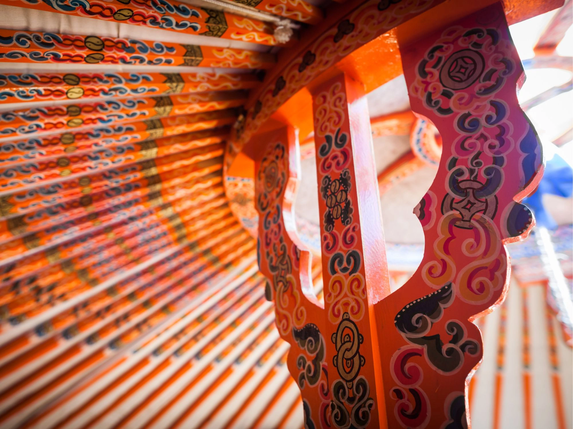 Brightly painted wooden beams inside a traditional Mongolian ger, reflecting cultural design and nomadic heritage.