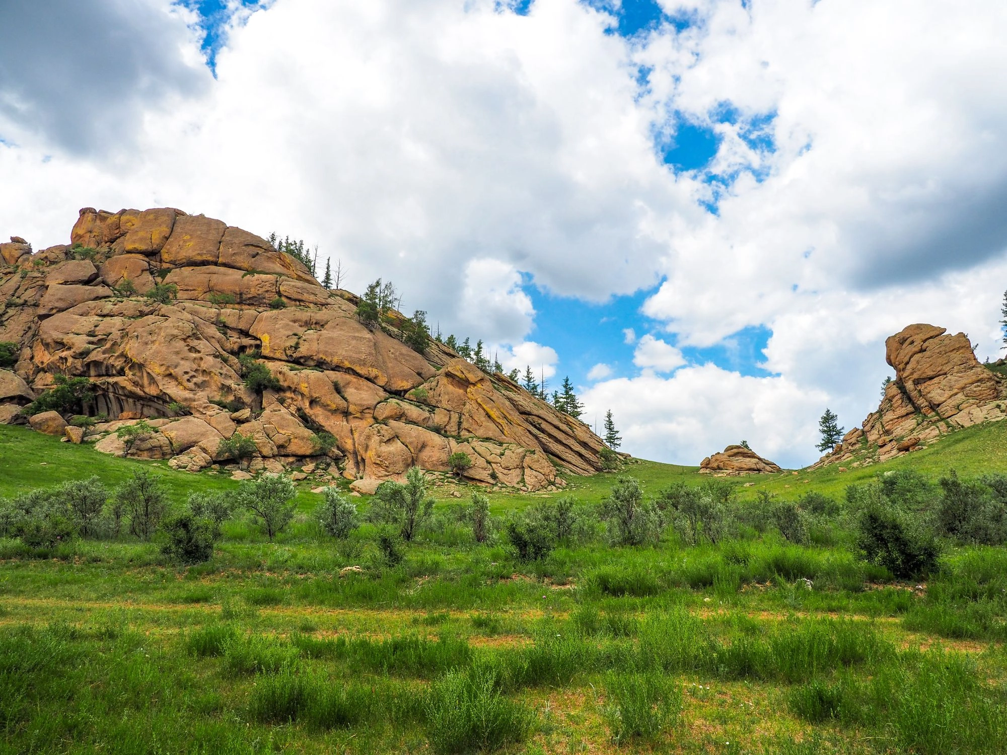 Lush green valley with rock formations in Terelj National Park, a top destination for Mongolia nature travel.