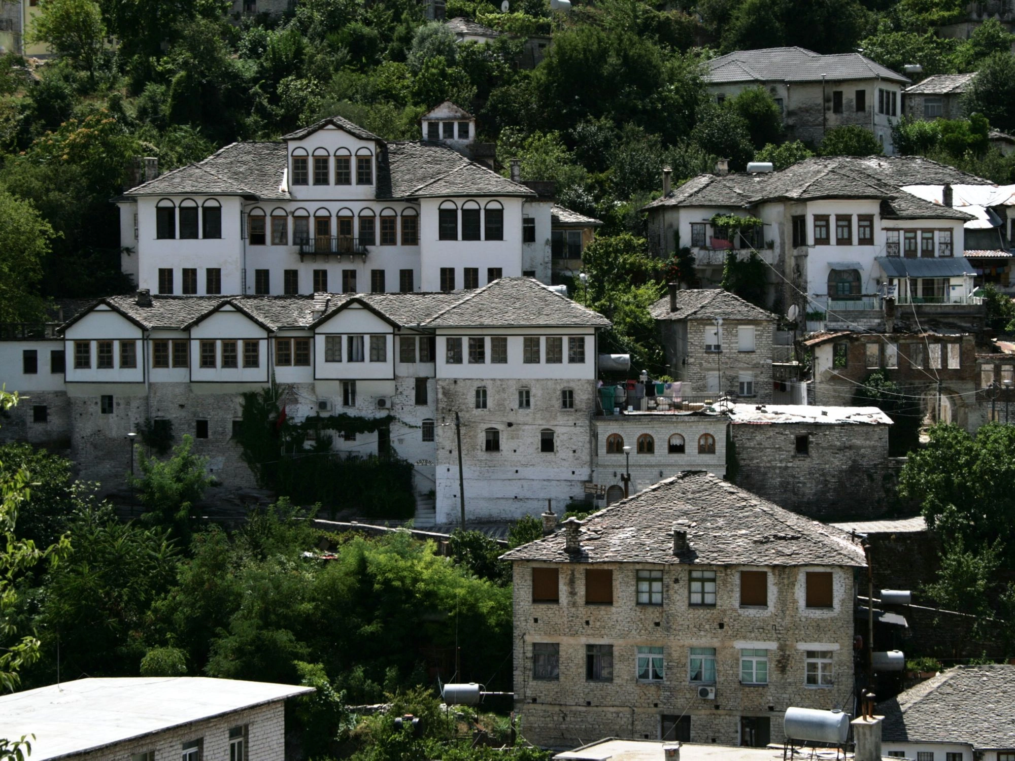 Cluster of historic stone houses with slate roofs in Gjirokastër, Albania, showcasing Ottoman architecture.