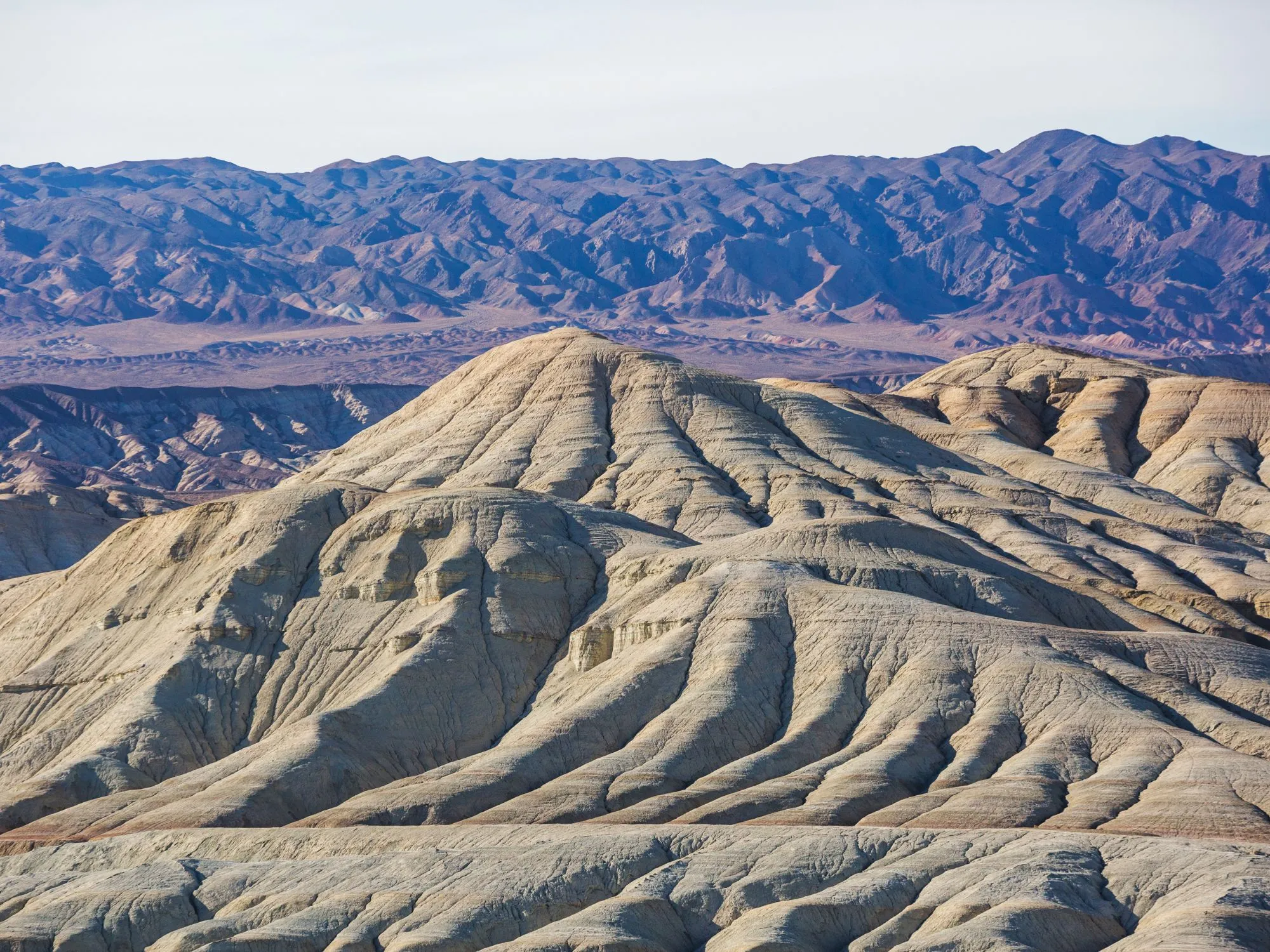 The colorful Aktau Mountains in Altyn Emel National Park, Kazakhstan, displaying vibrant layers of red, white, and green sedimentary rock.