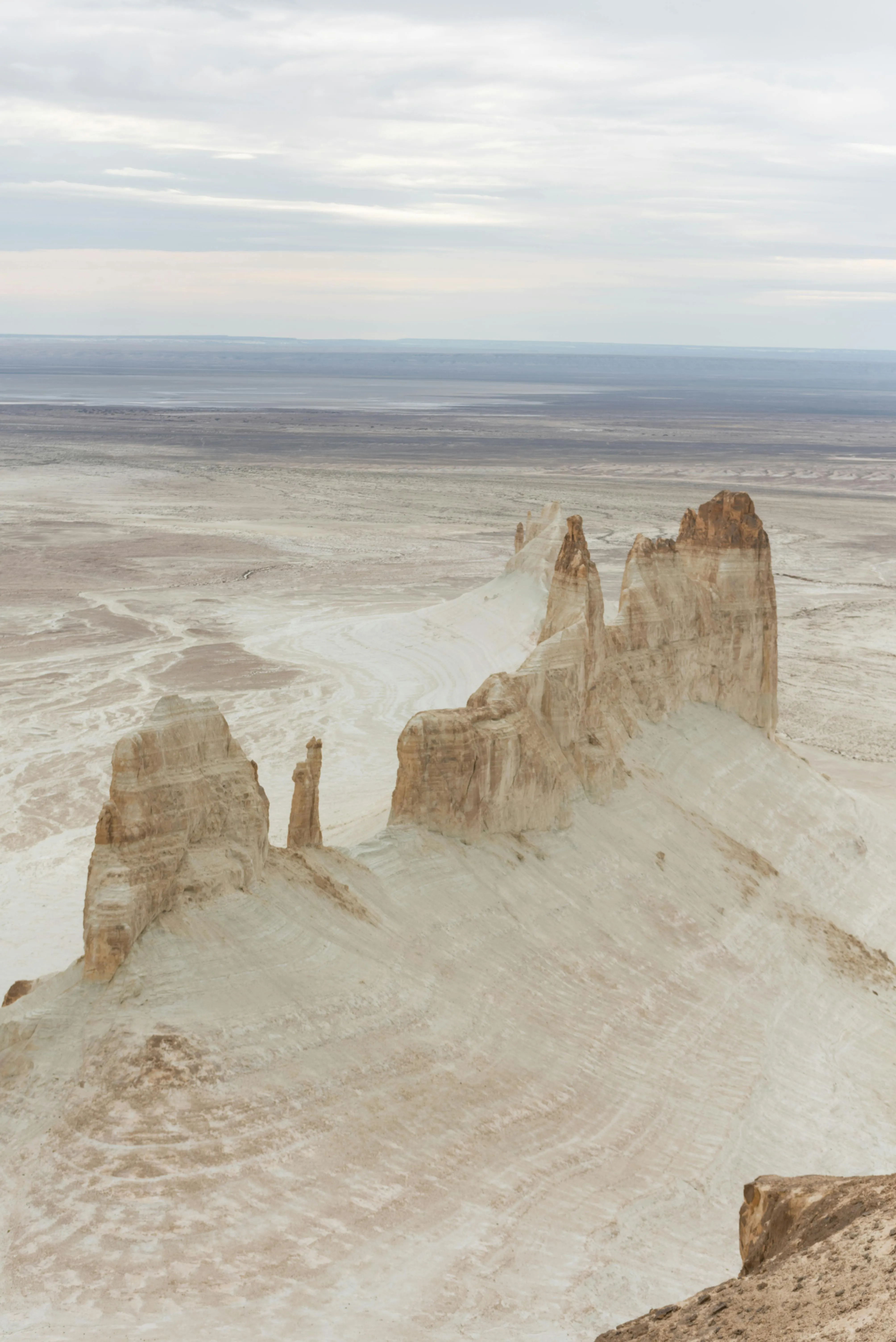 A striking geological formation in Mangystau, Kazakhstan, with layered sedimentary rock creating a dramatic, otherworldly landscape.