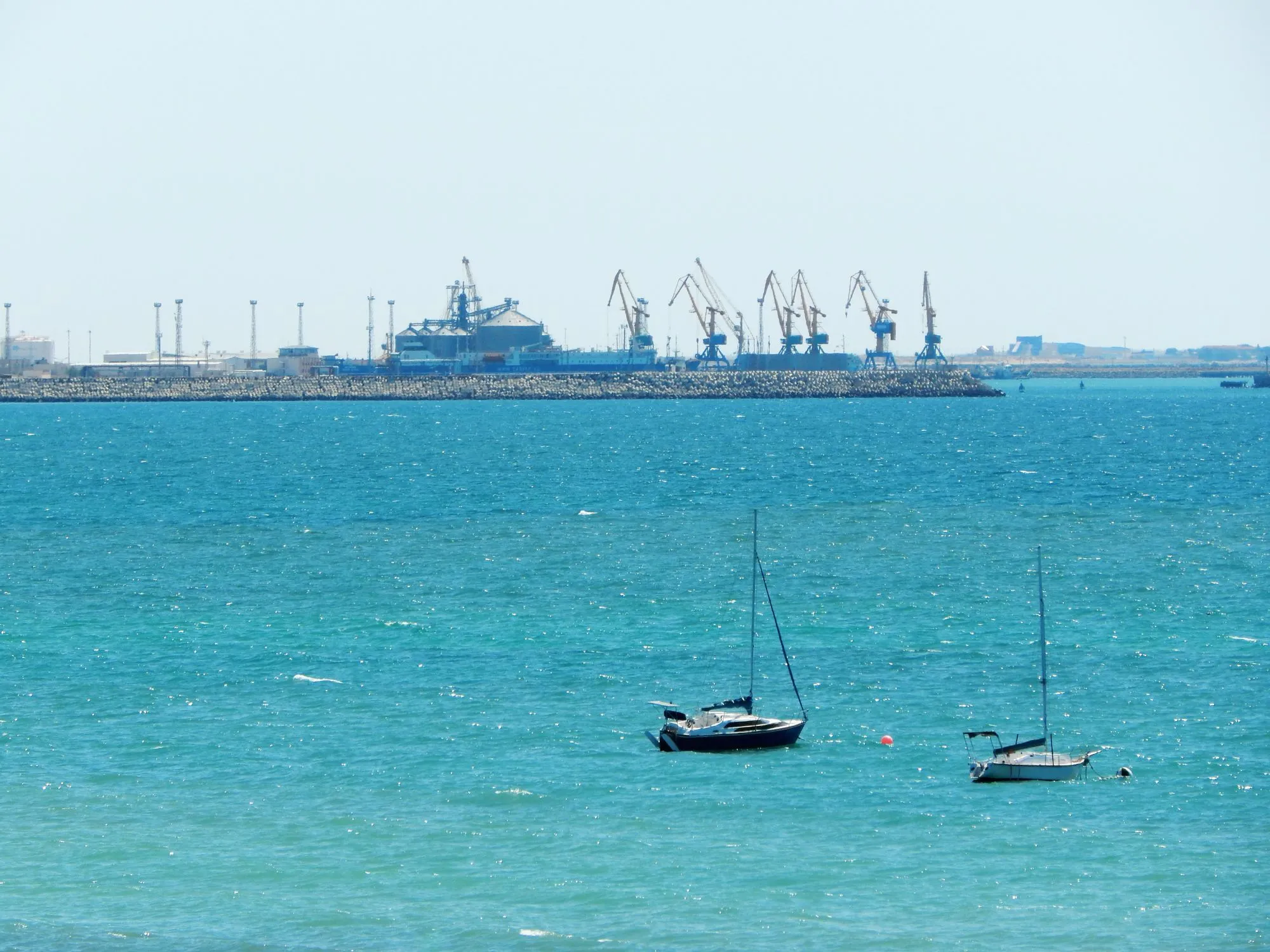 Aktau Port in Kazakhstan, showing a bustling coastal infrastructure with ships docked along the Caspian Sea.