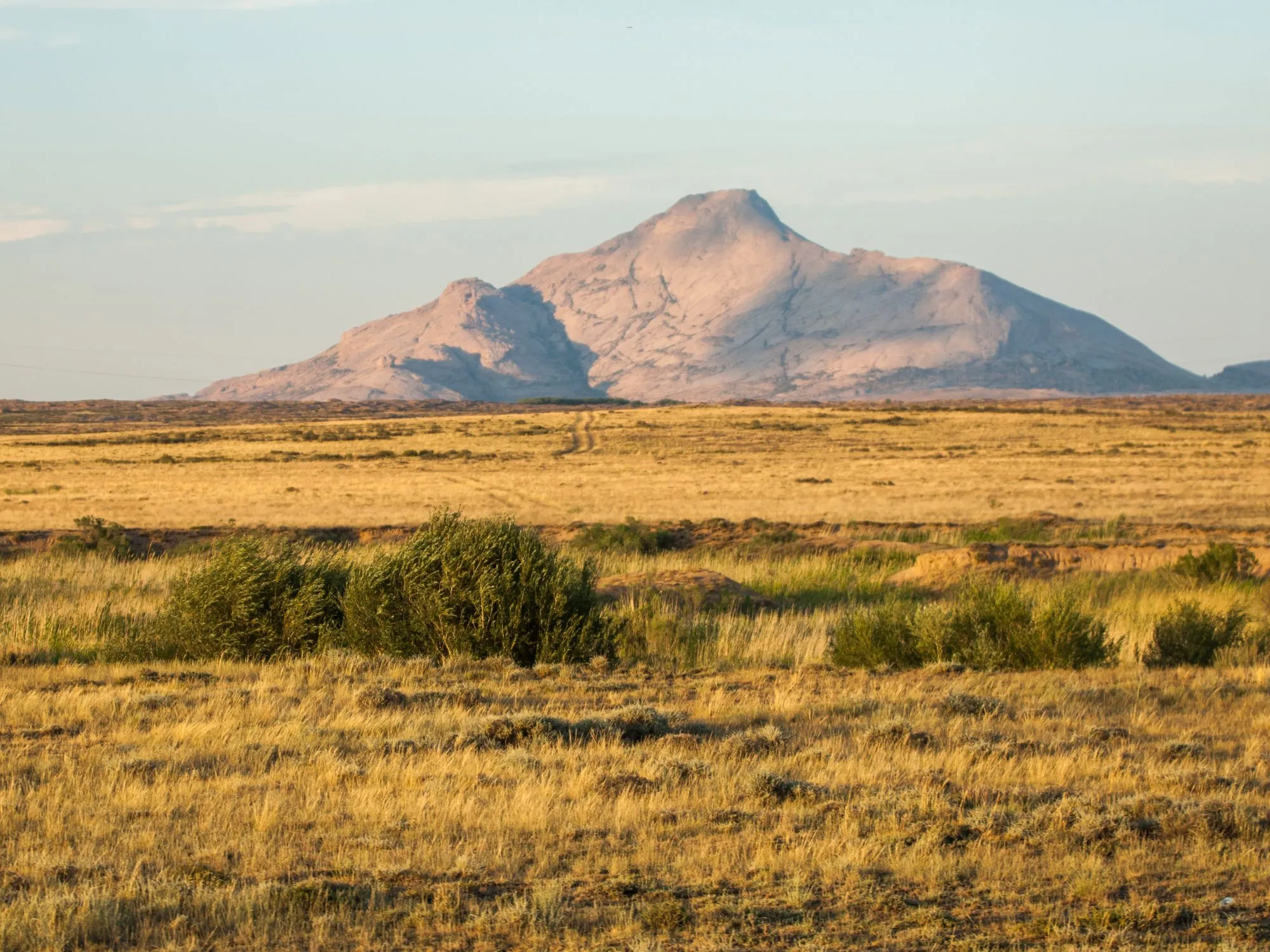 Shakpak-Ata Mountain rises over sunlit plains in Mangystau, Kazakhstan, blending natural beauty with historic charm.