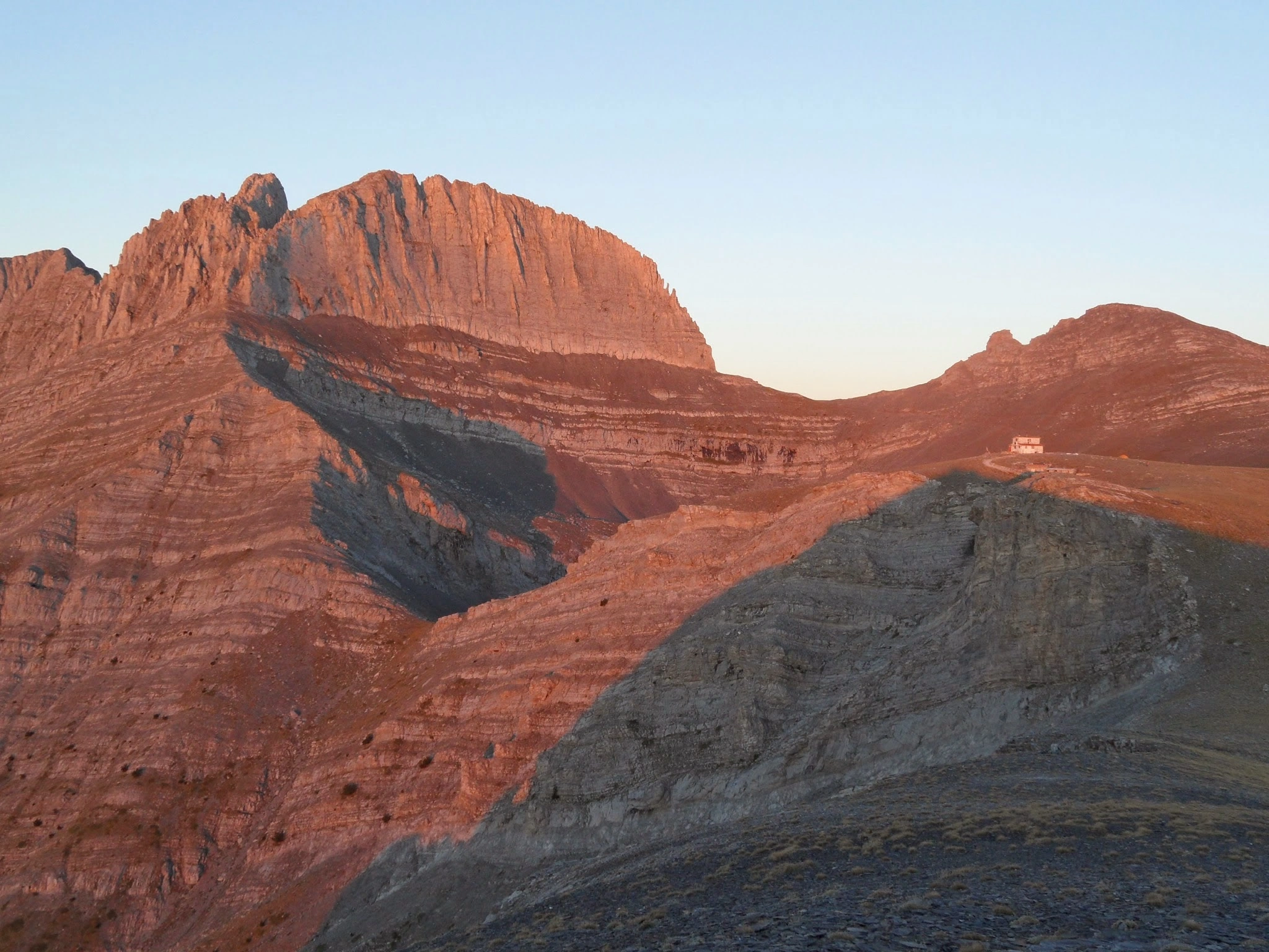 Alpenglow at sunset on the peaks of Mount Olympus, Greece, highlighting the dramatic ridges and hiking trails.