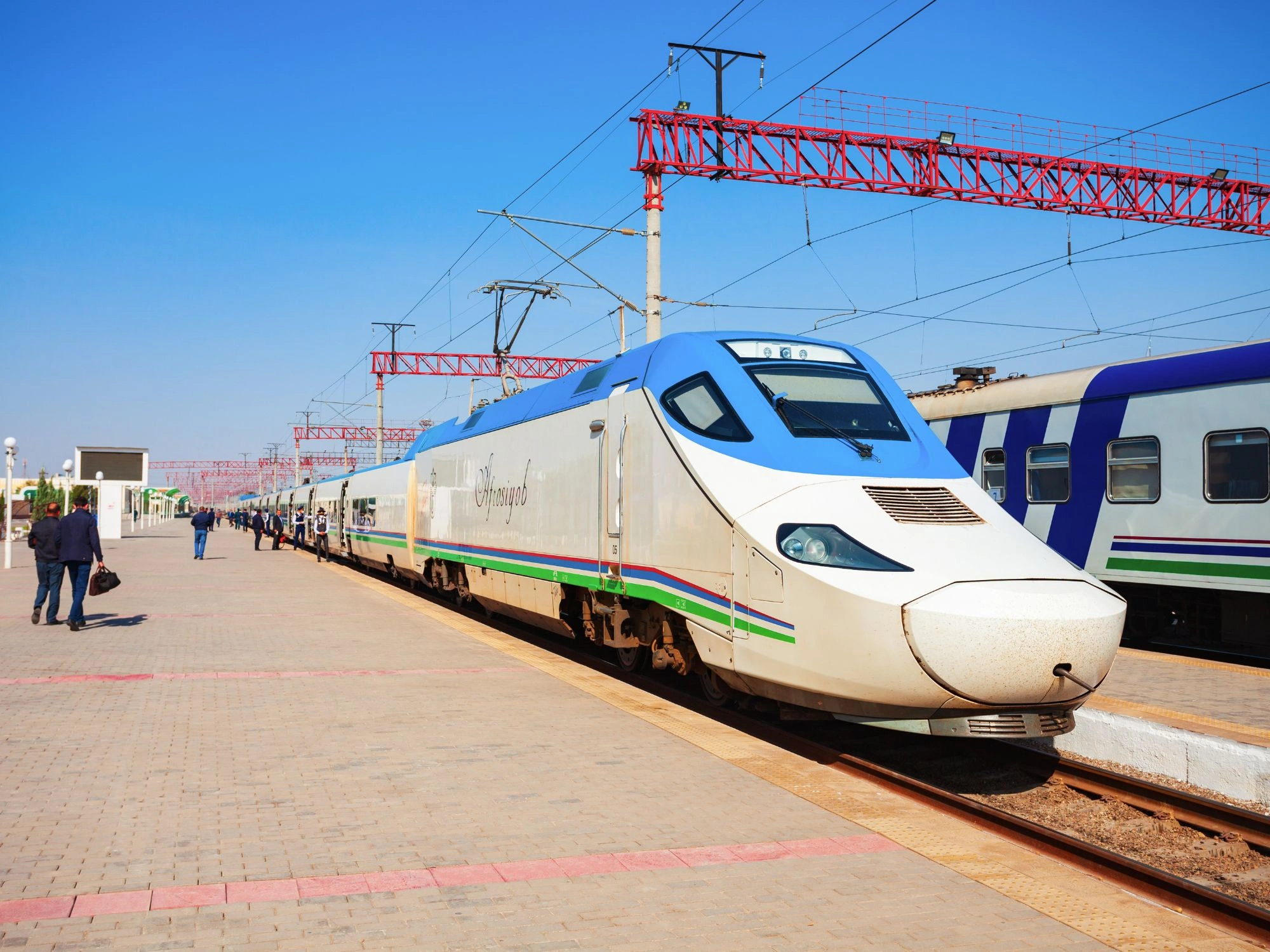 Modern Afrosiyob high-speed train at a sunlit station platform in Uzbekistan, connecting major Silk Road cities with fast, comfortable travel.