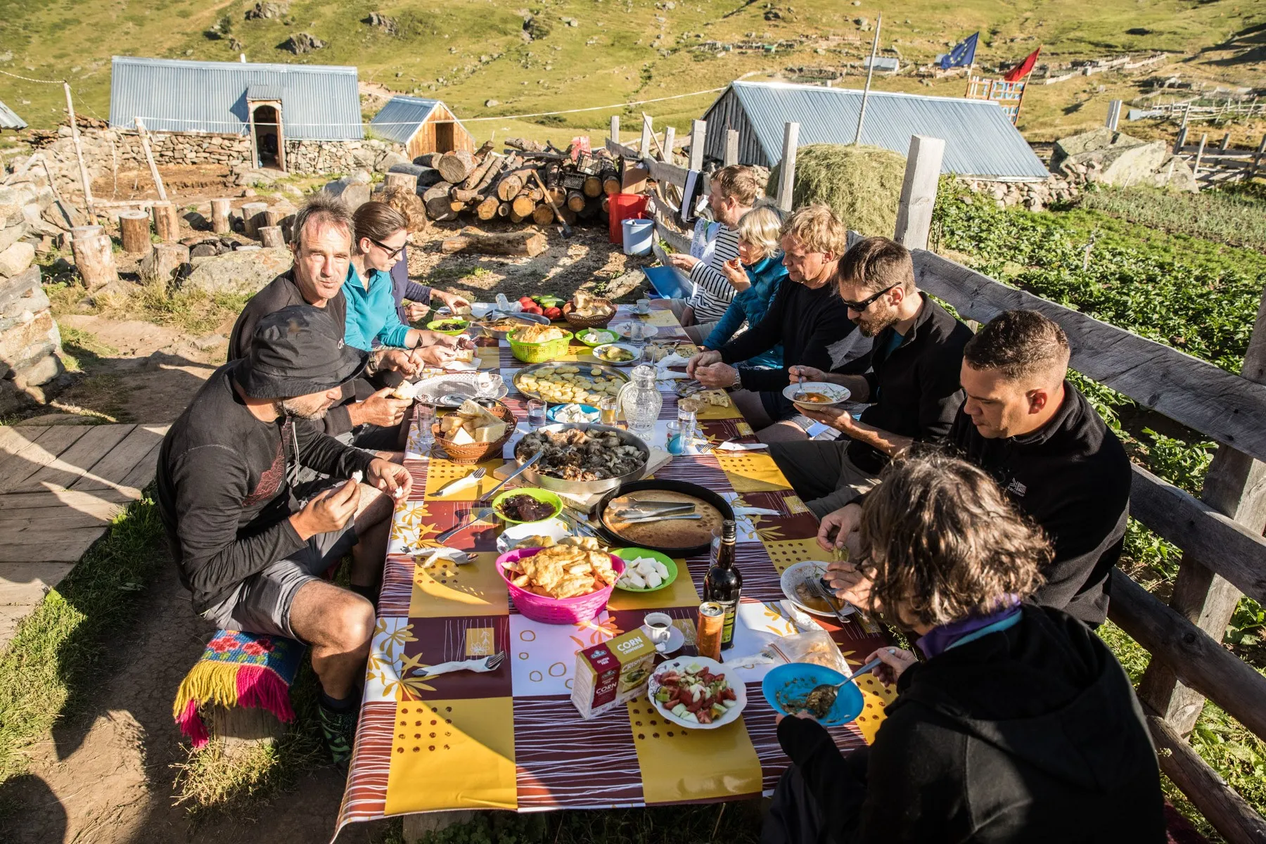 Group of hikers enjoying breakfast at a guesthouse along the Via Dinarica trail in Kosovo’s mountains.