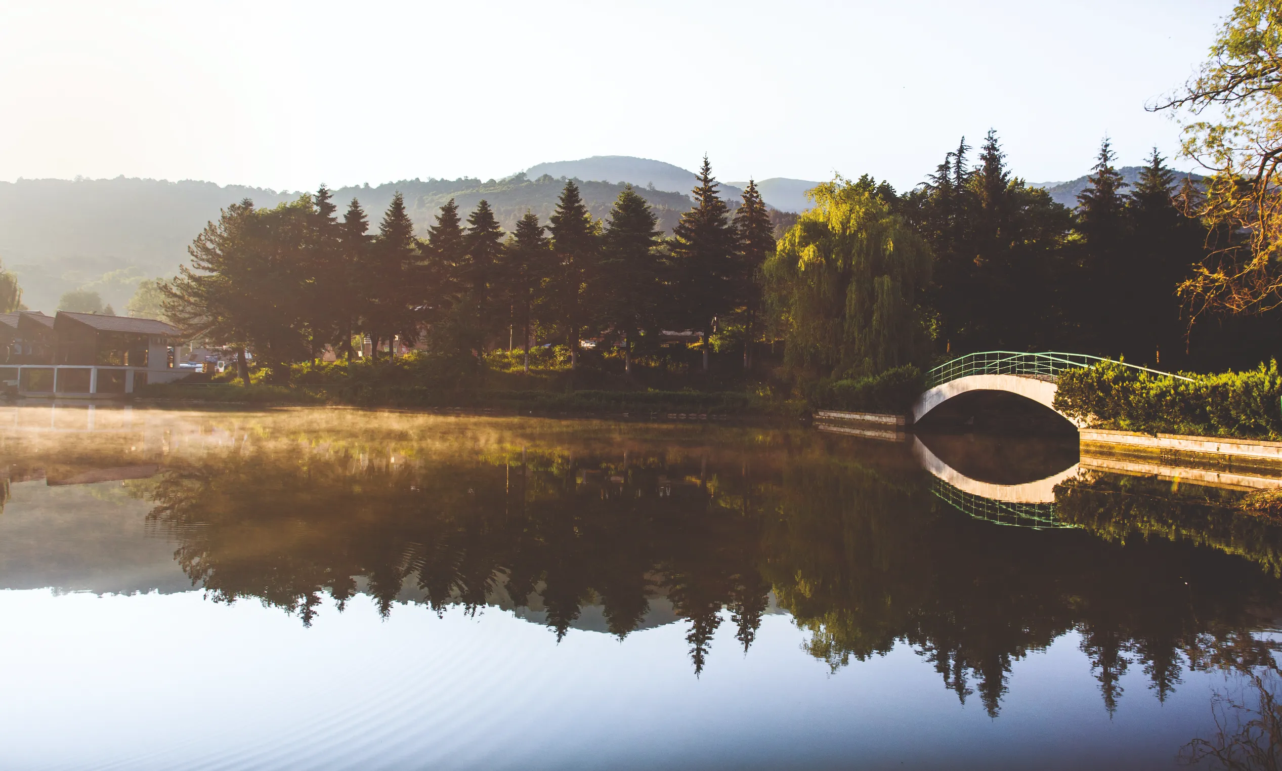Dilijan – Misty morning over a calm lake with a bridge and lush trees in Dilijan, Armenia’s "Little Switzerland."