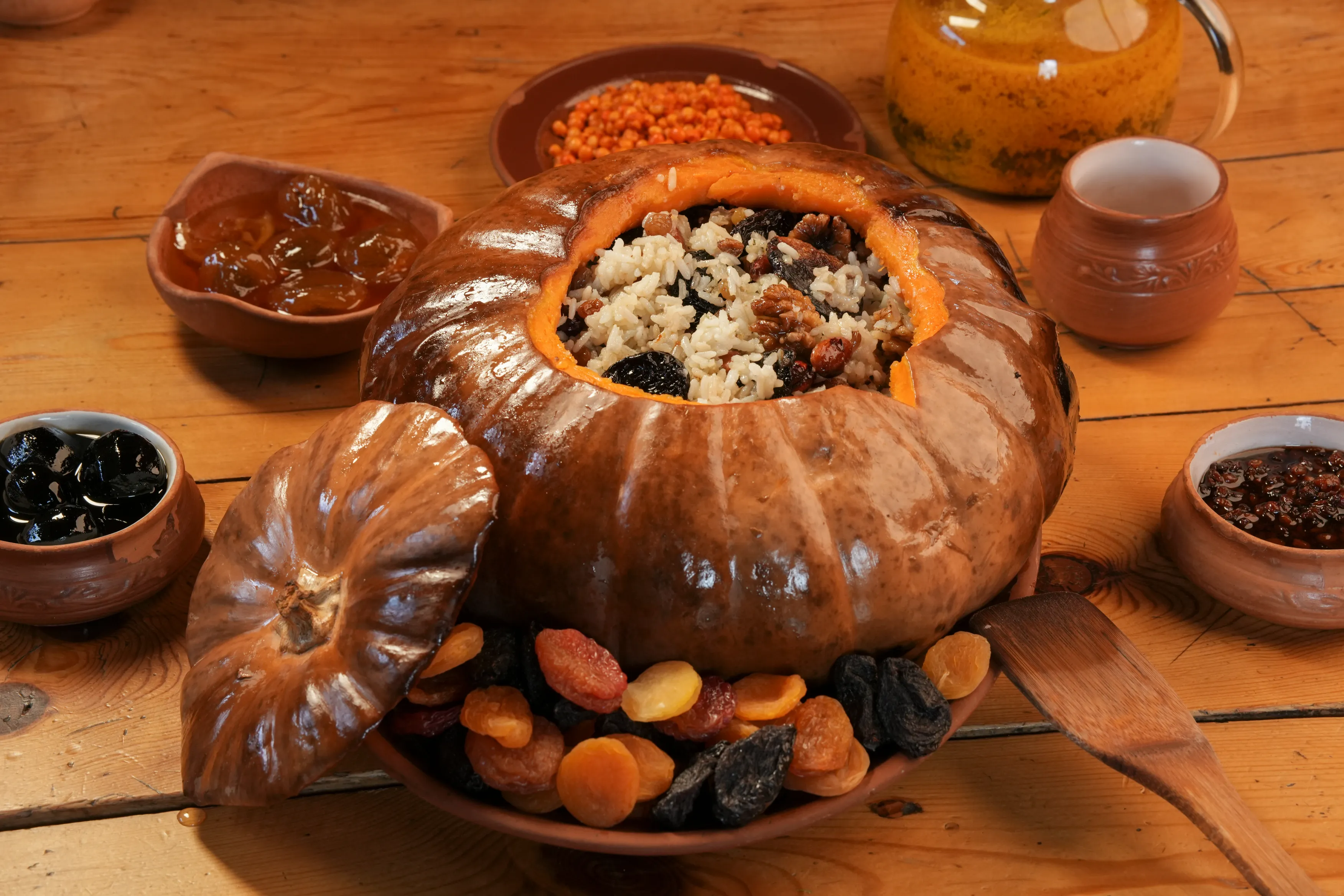 Ghapama, a traditional Armenian dish of stuffed pumpkin with rice, dried fruits, and nuts, served on a wooden table.