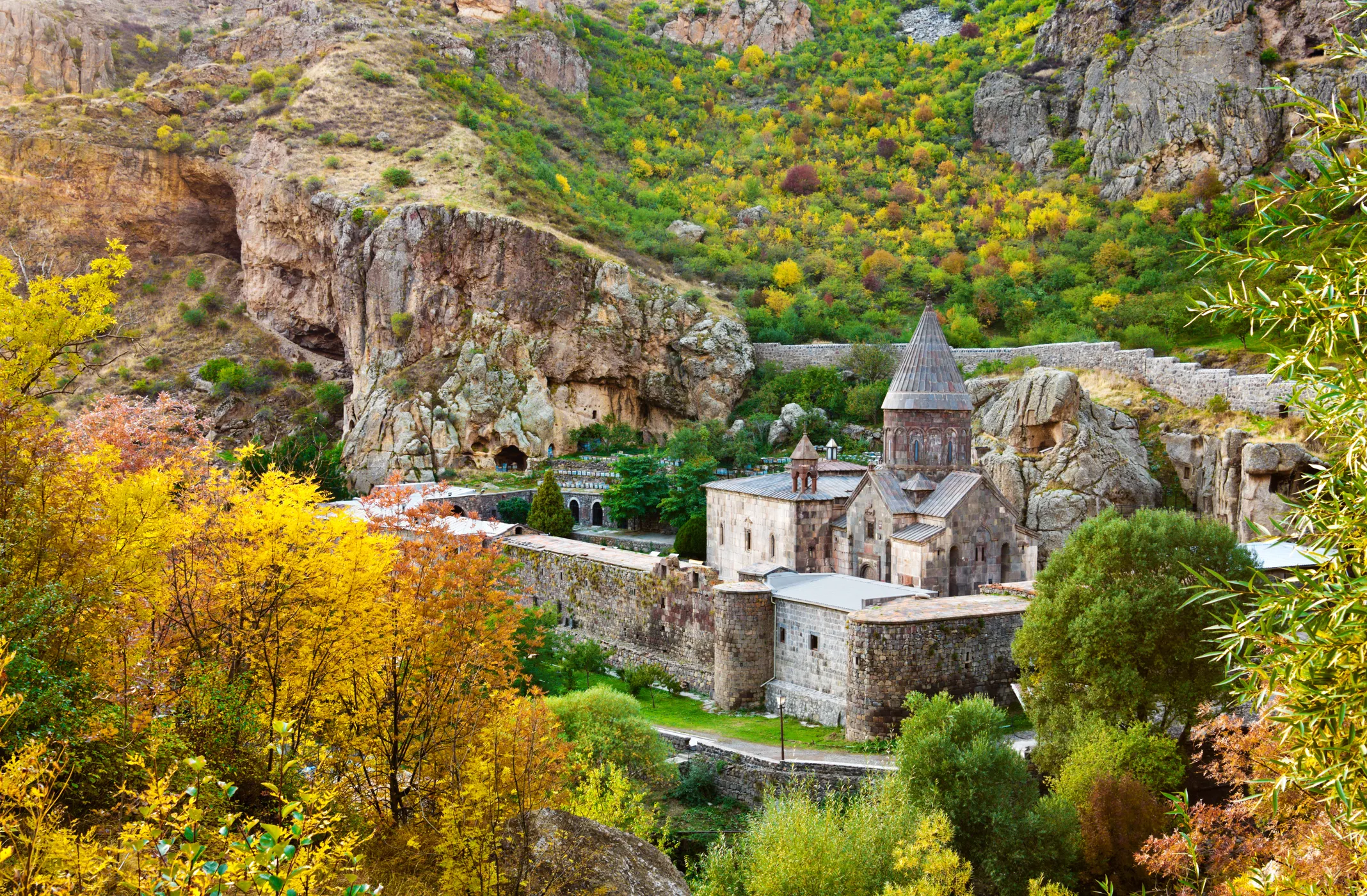Geghard Monastery in Armenia, a medieval cave monastery surrounded by lush mountains.