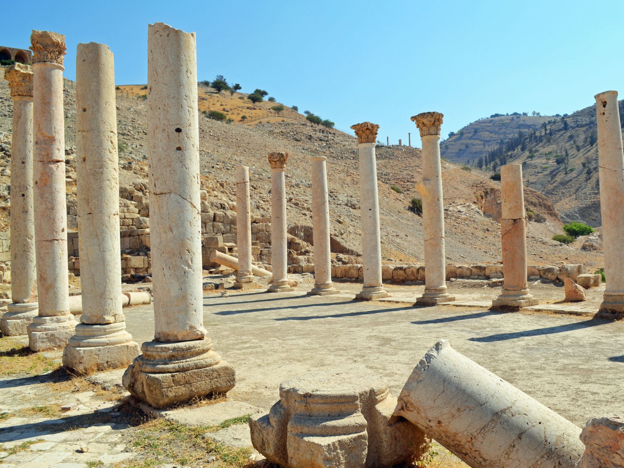 Ancient ruins and standing columns in Pella, Greece – Hellenistic heritage in sunlit hills.