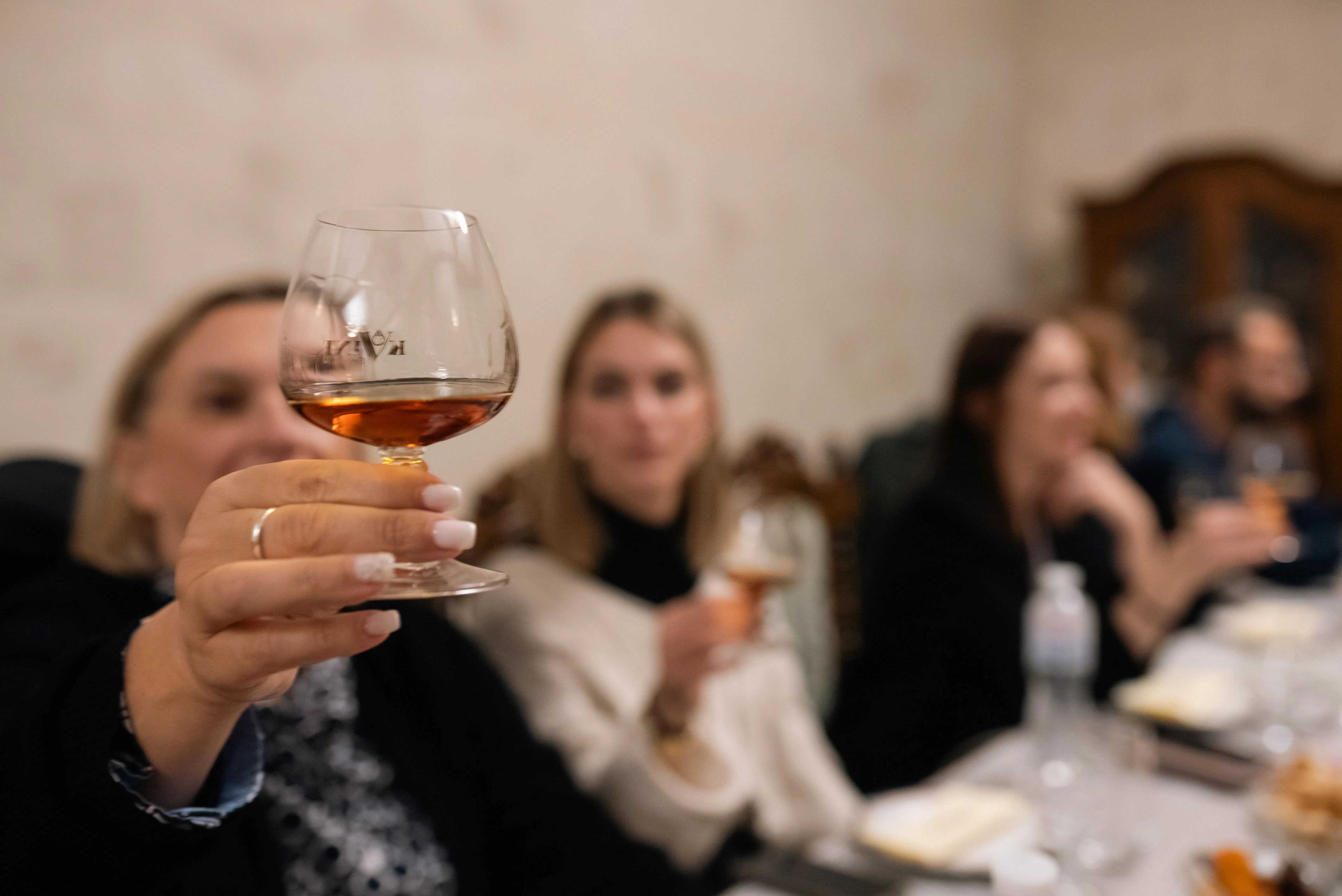 Close-up of a woman holding a glass of cognac at Kvint Cognac Factory tasting room