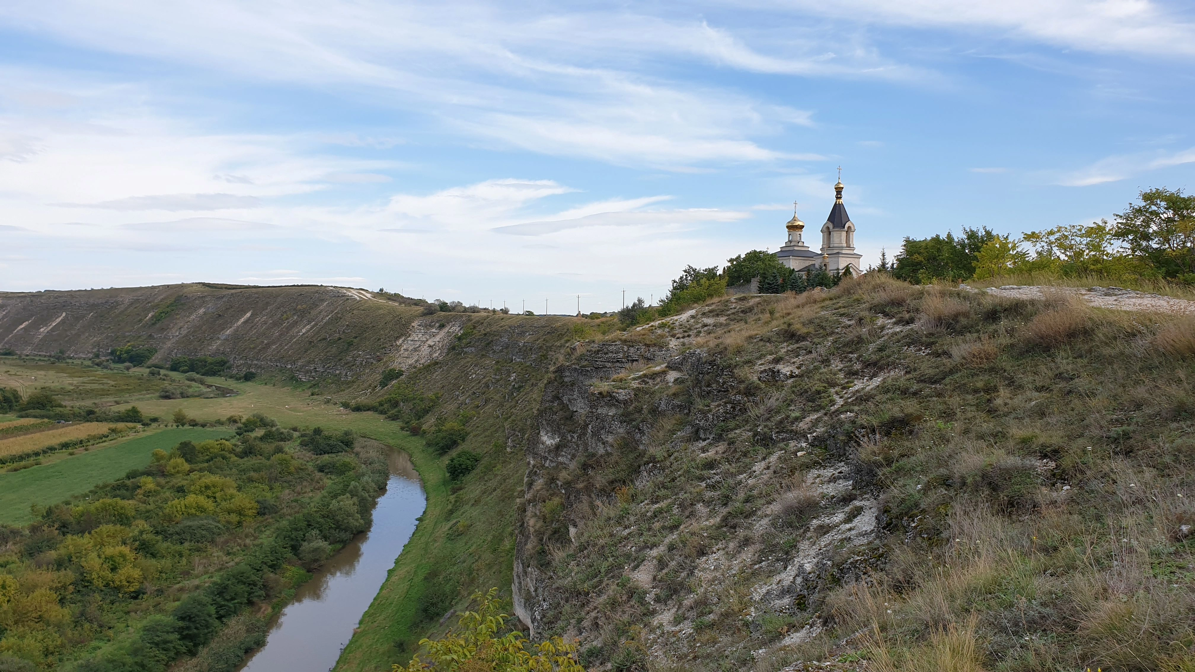 Orheiul Vechi monastery overlooking the river valley in Moldova, golden domes gleaming.