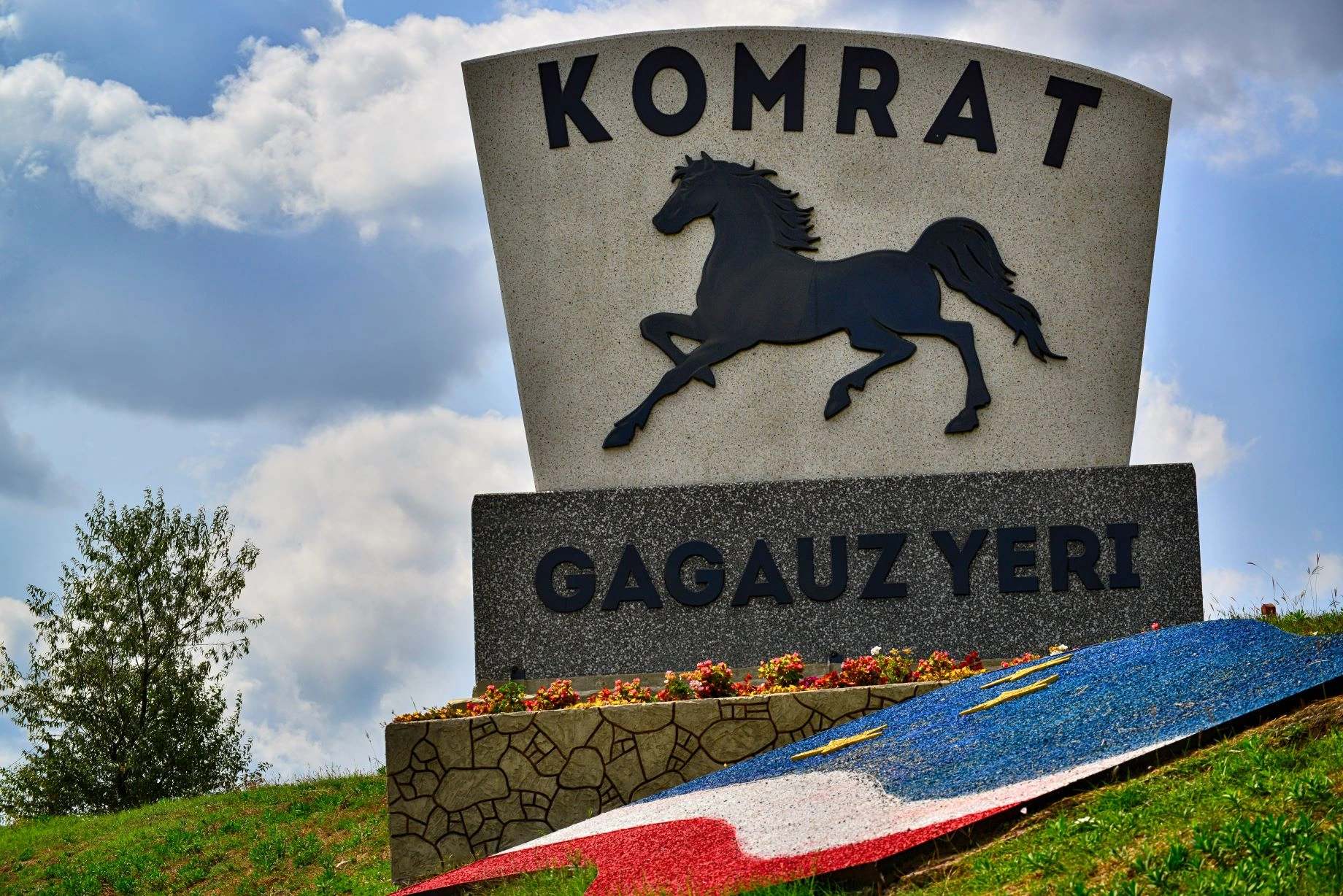 Monument with horse sculpture and "KOMRAT GAGAUZ YERI" sign in Comrat, Moldova