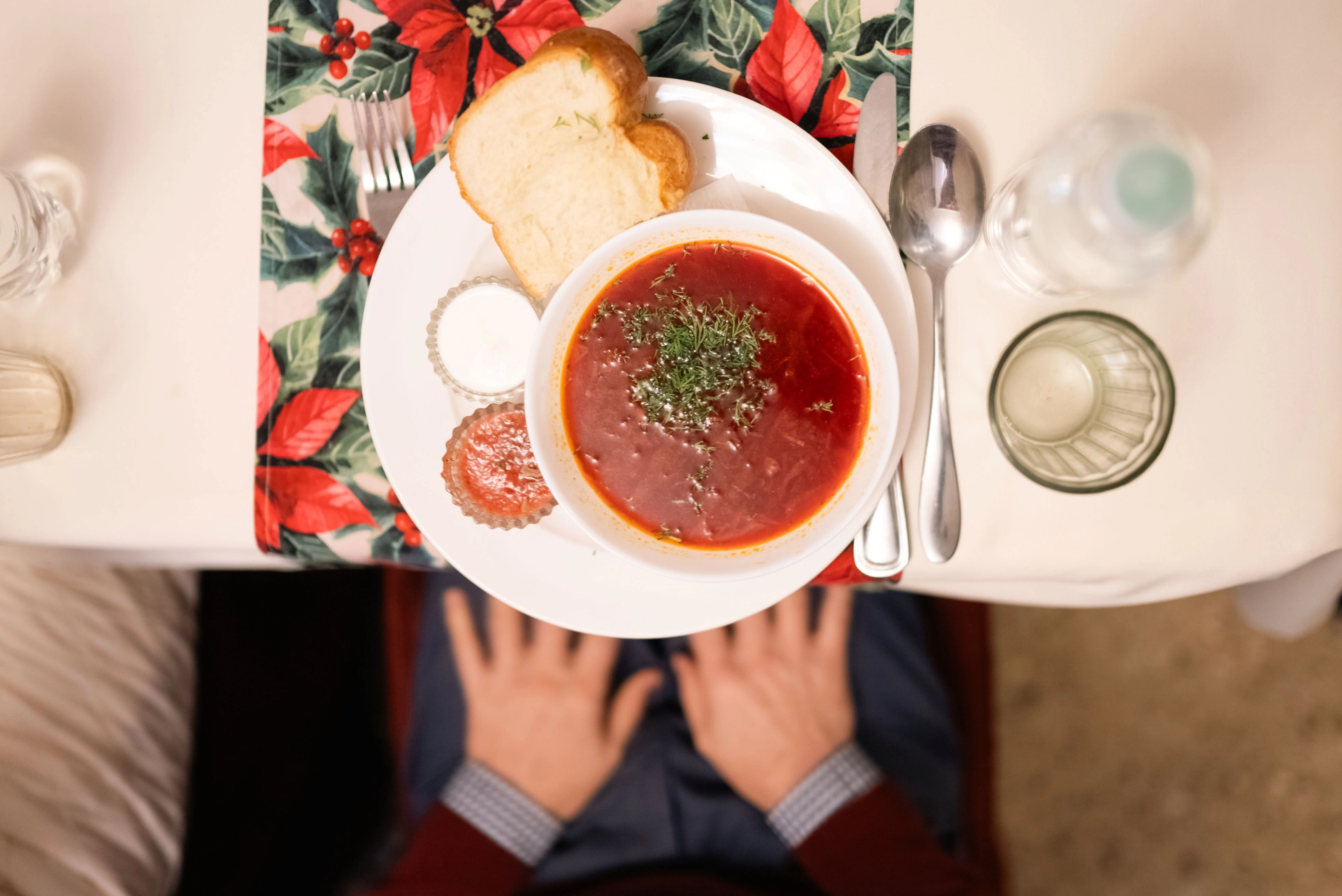 Traditional Moldovan borscht soup served with bread and condiments on a festive table.