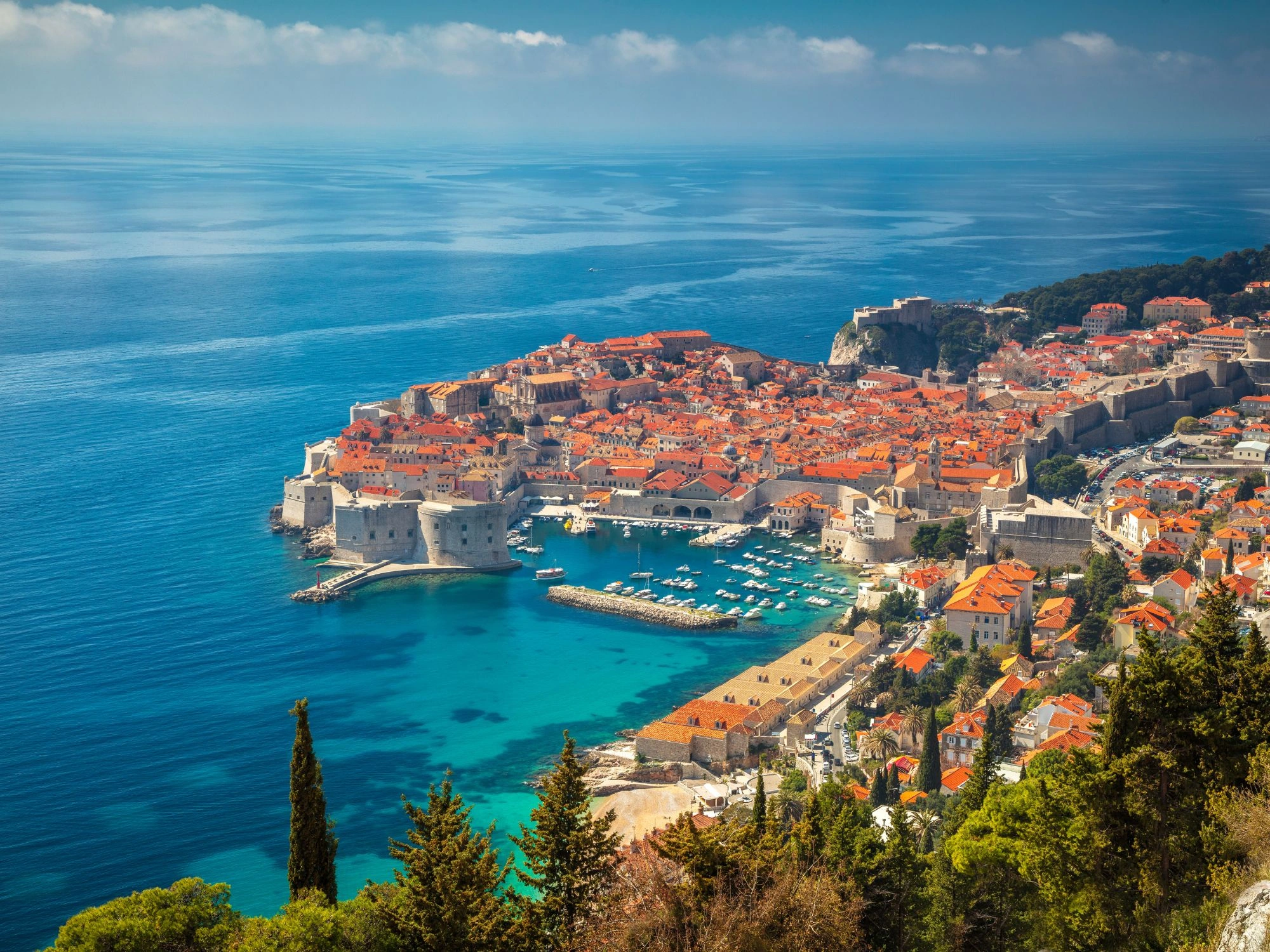 Dubrovnik, Croatia – aerial view of old town walls and Adriatic Sea with boats in the harbor.