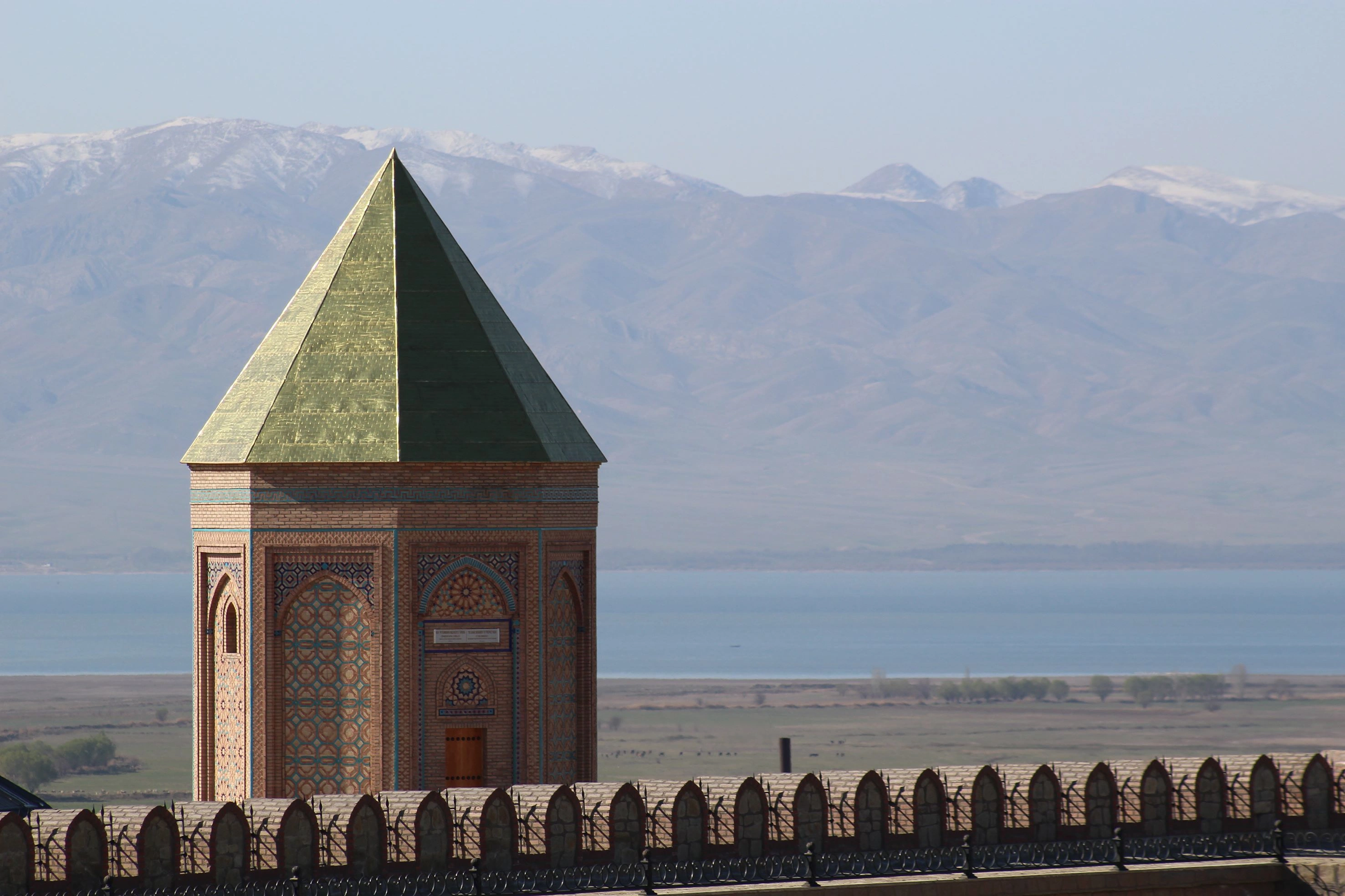 The tomb of Prophet Noah in Nakhchivan, with green pyramid roof and mountain backdrop.