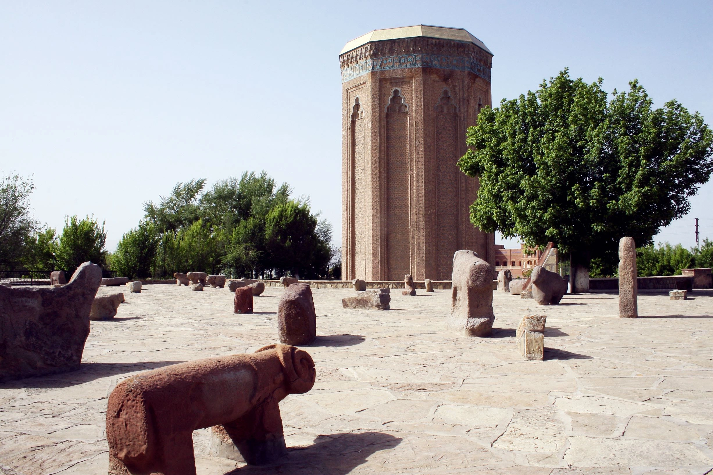 Ancient Momine Khatun Mausoleum in Nakhchivan, surrounded by ram-shaped stone sculptures.