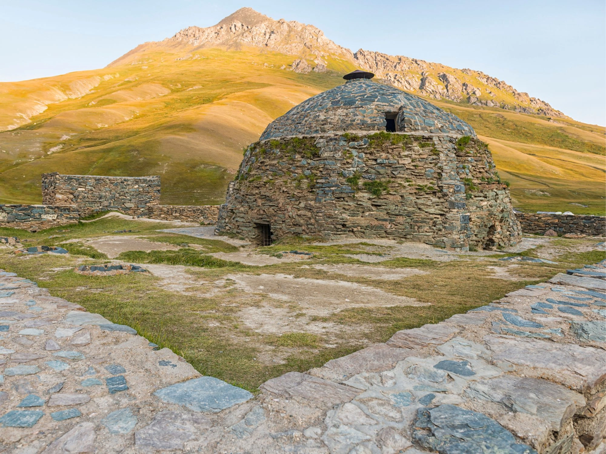 Stone caravanserai of Tash Rabat nestled in green Kyrgyz mountains near the Silk Road.