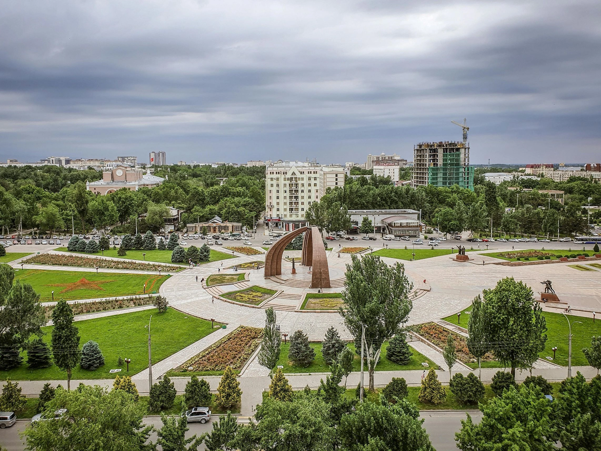Bishkek city center view with green parks, buildings, and cloudy skies in Kyrgyzstan.