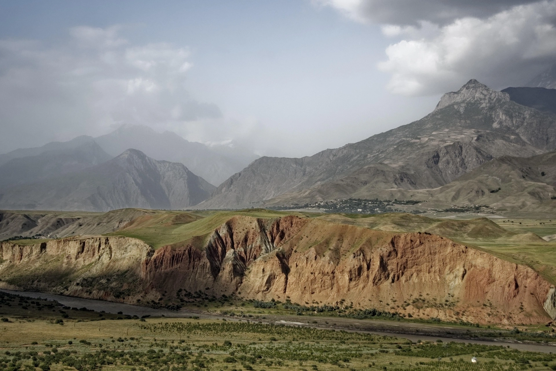 Red rock canyon and distant hazy mountains on the arid plains of southern Tajikistan.