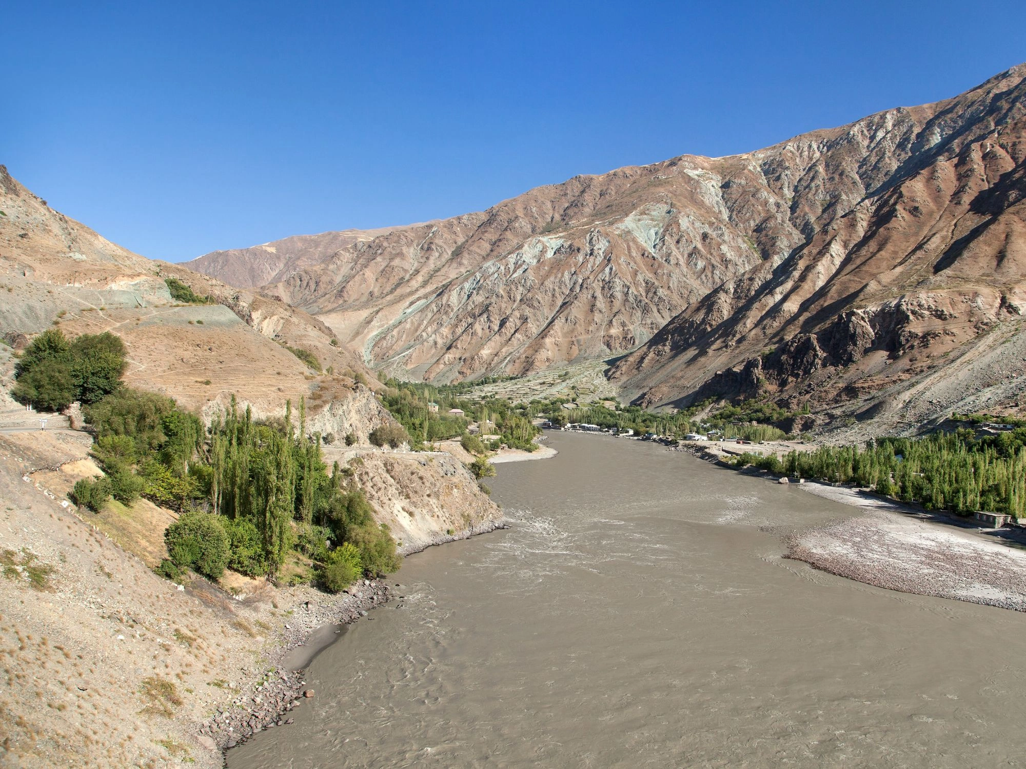 Panj River flowing between steep mountain slopes along the scenic Pamir Highway in Tajikistan.