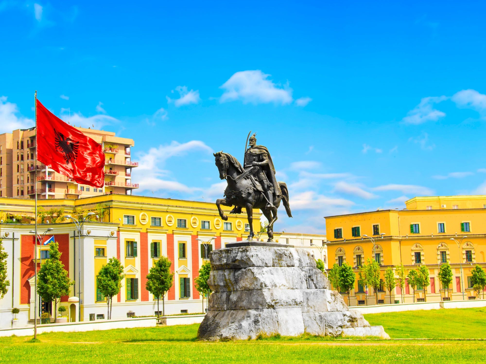 Skanderbeg Square in Tirana, Albania, with the Skanderbeg statue and the Albanian flag flying proudly.