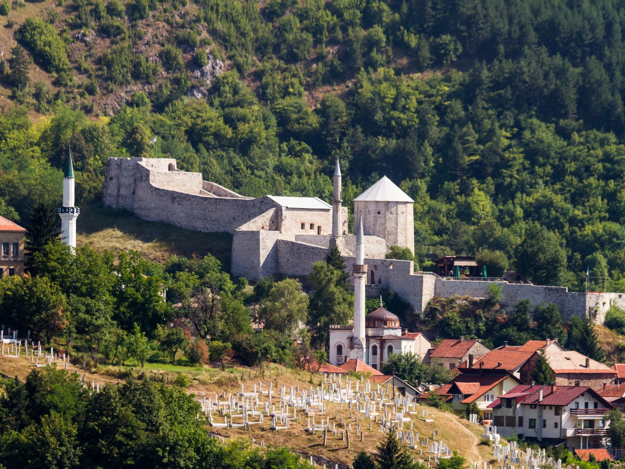 Travnik Old Town fortress and hillside mosques surrounded by forest in Bosnia and Herzegovina.