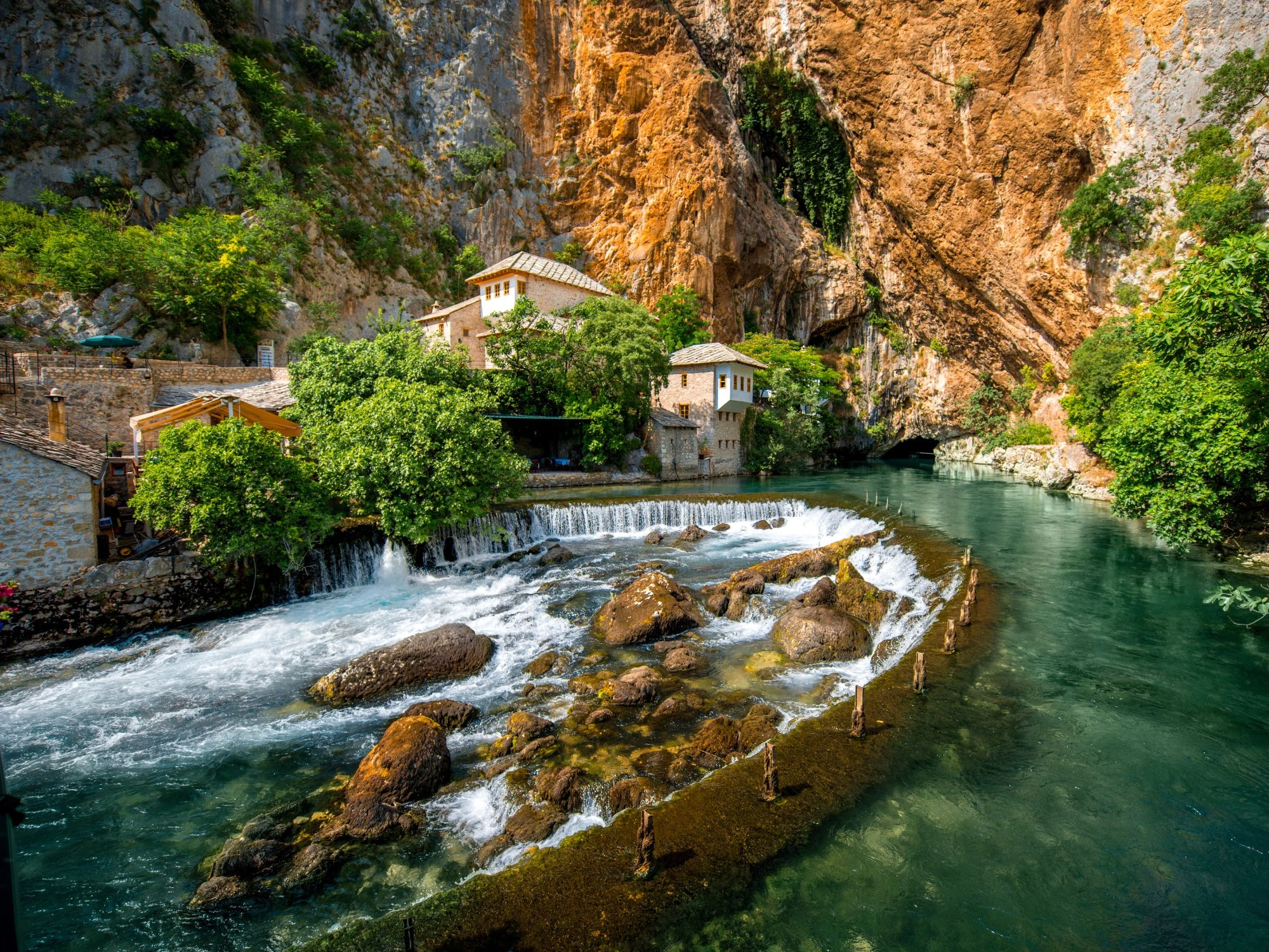 Blagaj Tekija monastery nestled by the Buna River spring, under dramatic cliffs in Bosnia and Herzegovina.