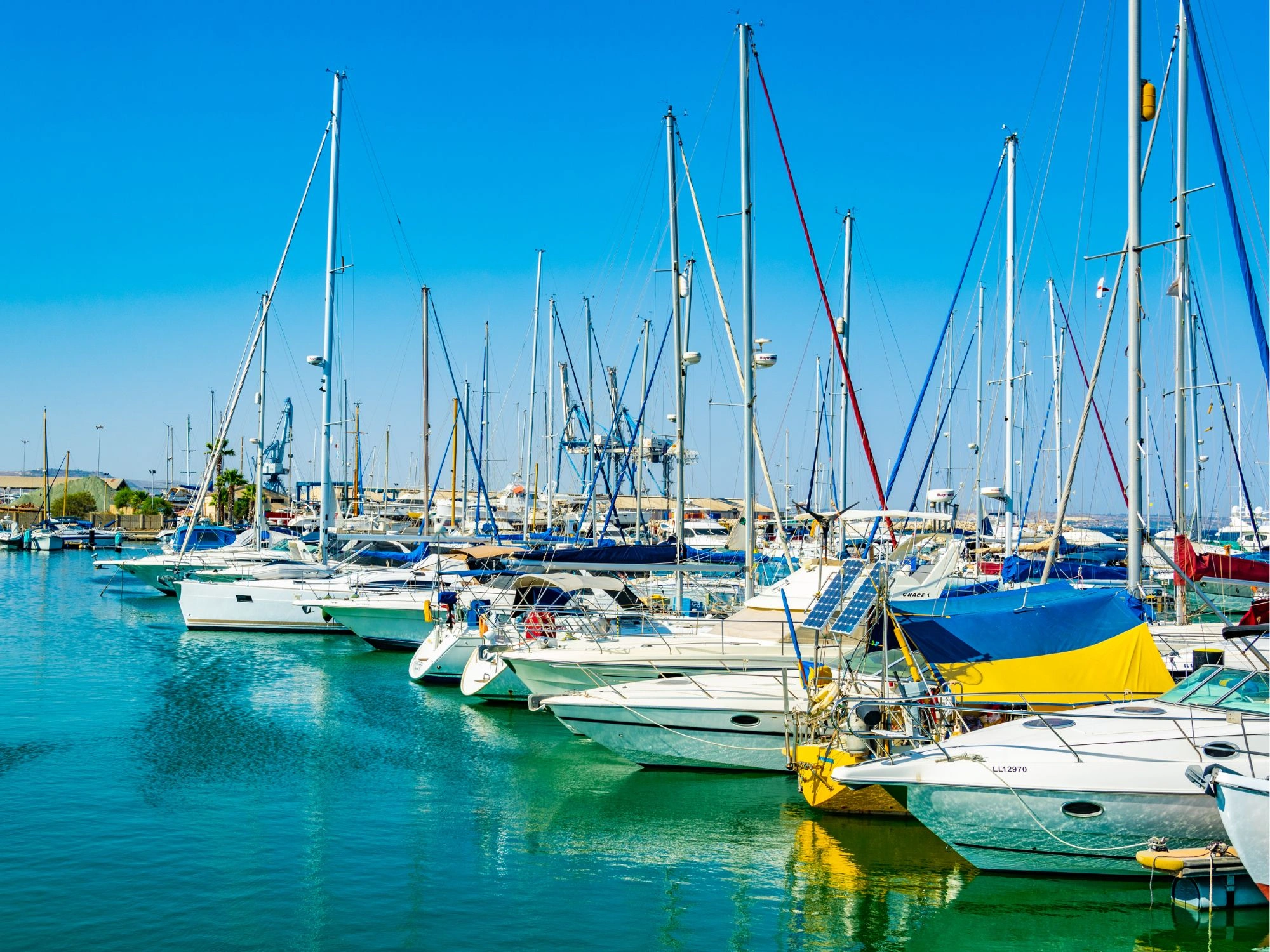 Boats docked in the vibrant marina of Larnaca, Cyprus, under a clear blue sky.