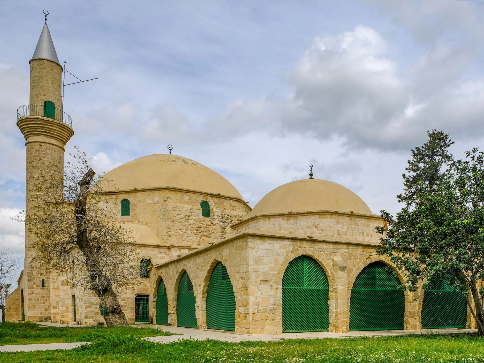 Hala Sultan Tekke mosque in Larnaca, Cyprus, with domes and green lattice doors.