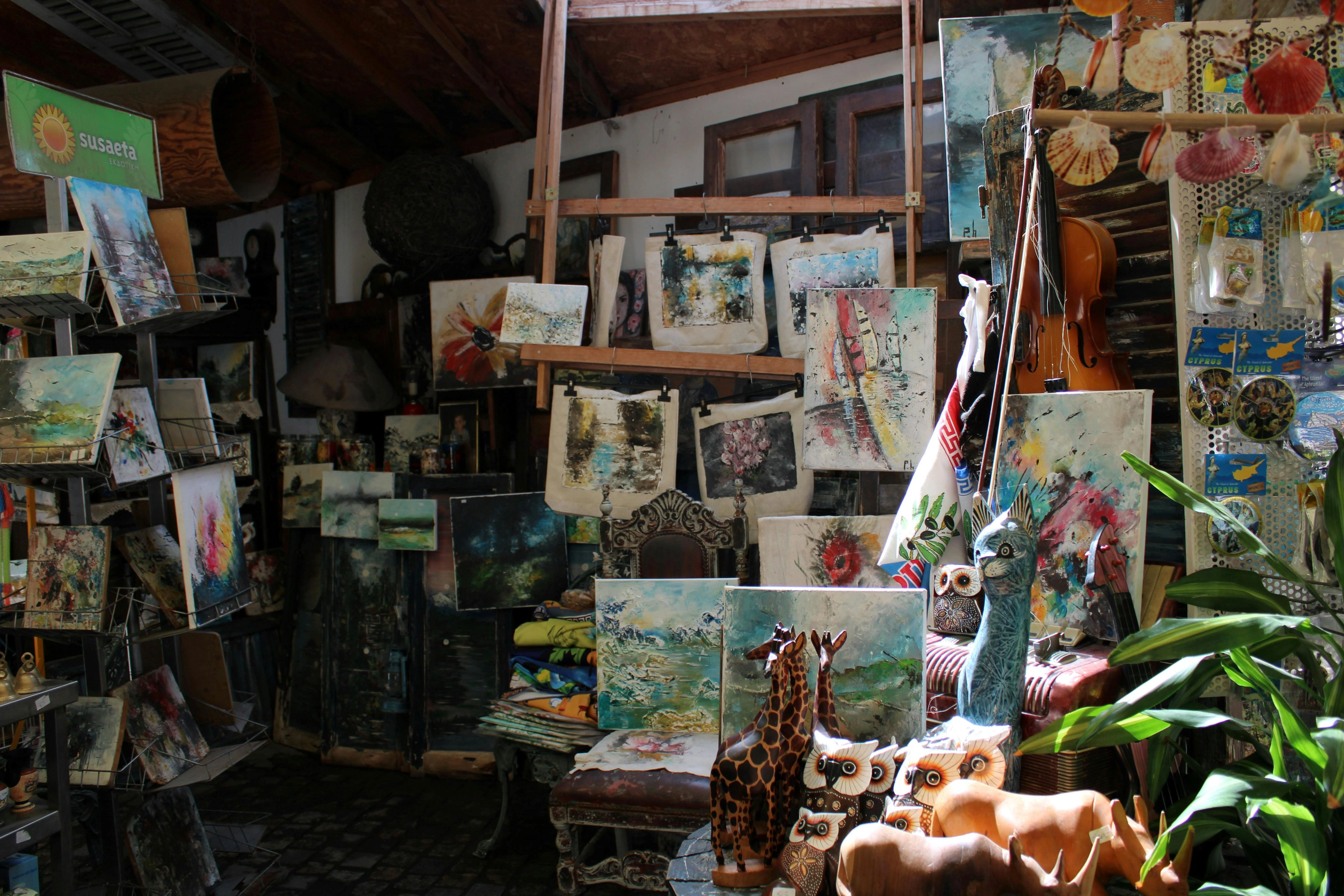 Artisan shop with Cypriot paintings, wood carvings, and handmade crafts on display.