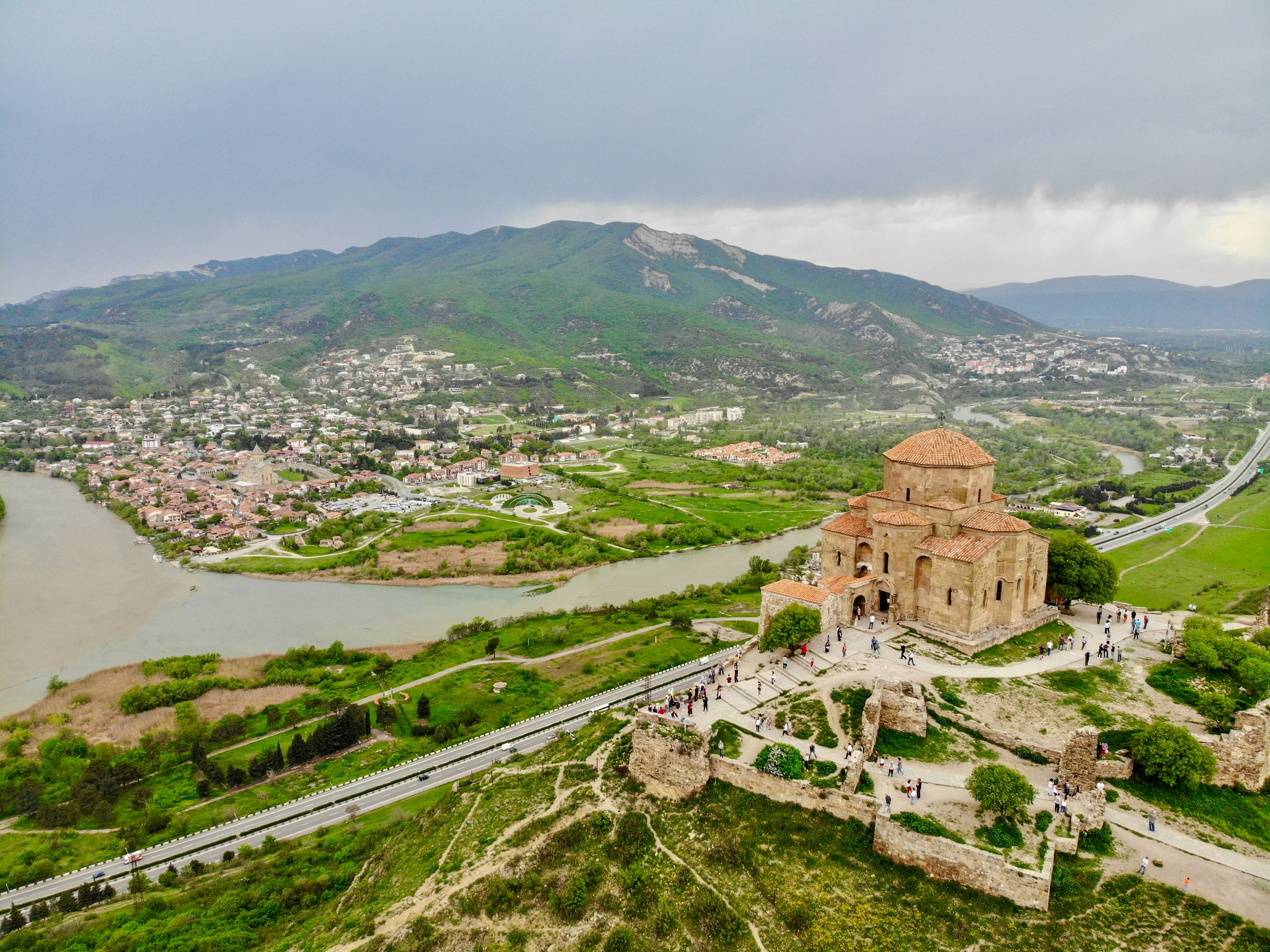 Aerial view of Jvari Monastery overlooking Mtskheta, rivers, and lush Georgian countryside.