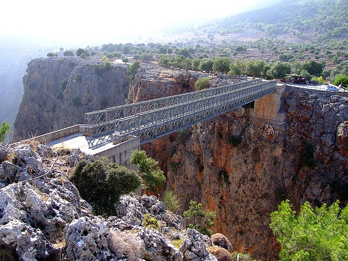 Steel bridge over Aradhena Gorge spans deep canyon with sheer cliffs and scattered trees.