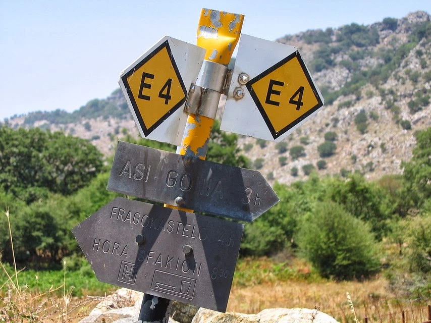 Metal trail sign on Crete’s E4 hiking route pointing toward Asi Gonia, Frangokastello, Hora Sfakion.
