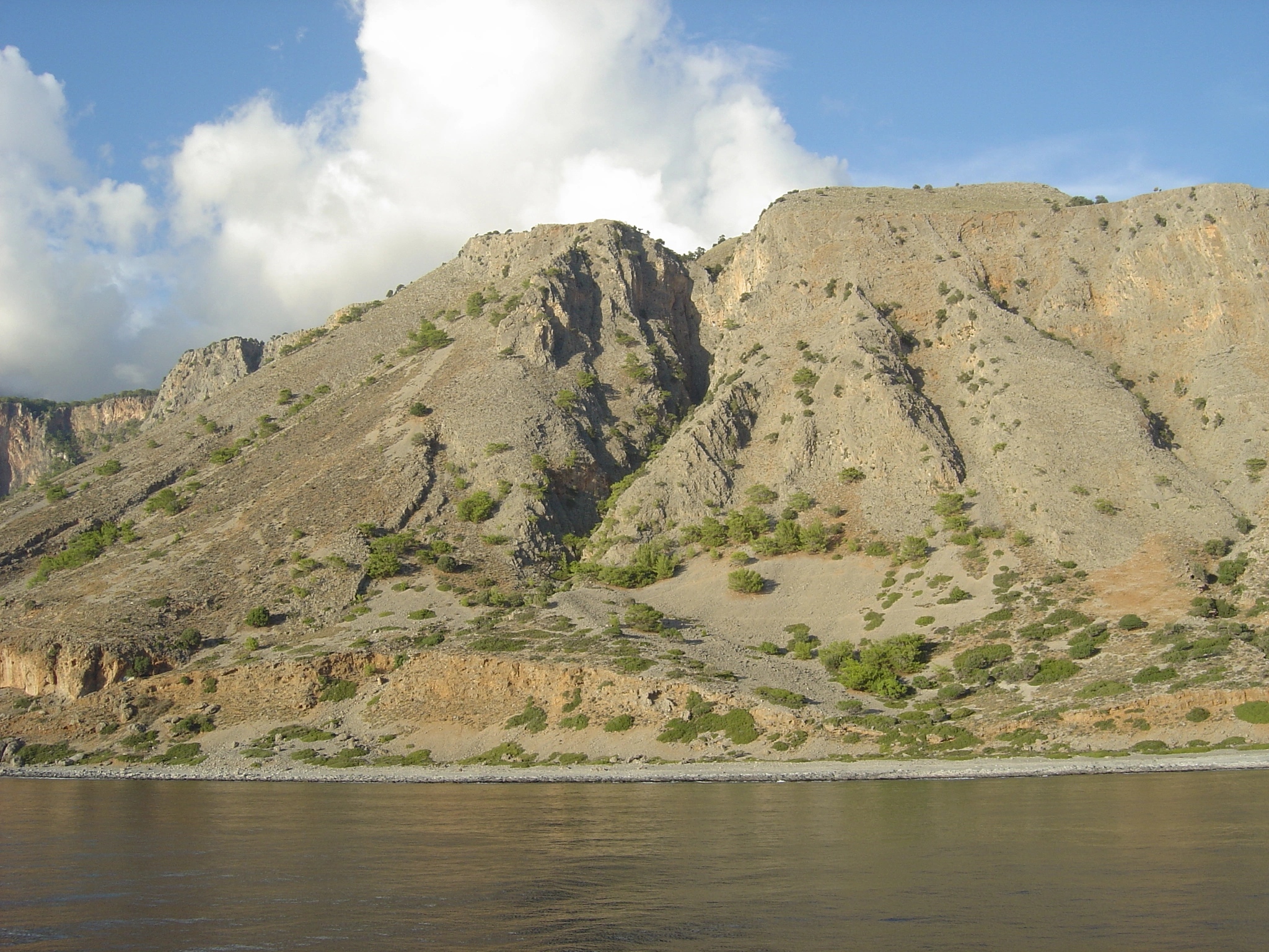 Rugged hills and rocky terrain on Crete’s south coast, overlooking the calm Mediterranean Sea.