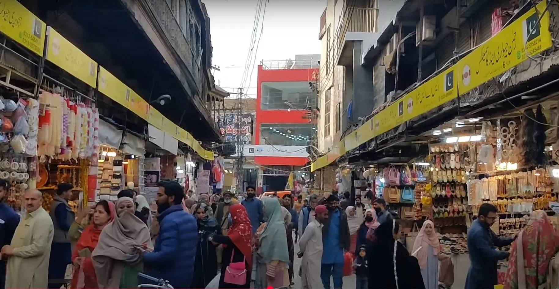 Raja Bazaar Rawalpindi, busy market street with shops and crowds shopping.
