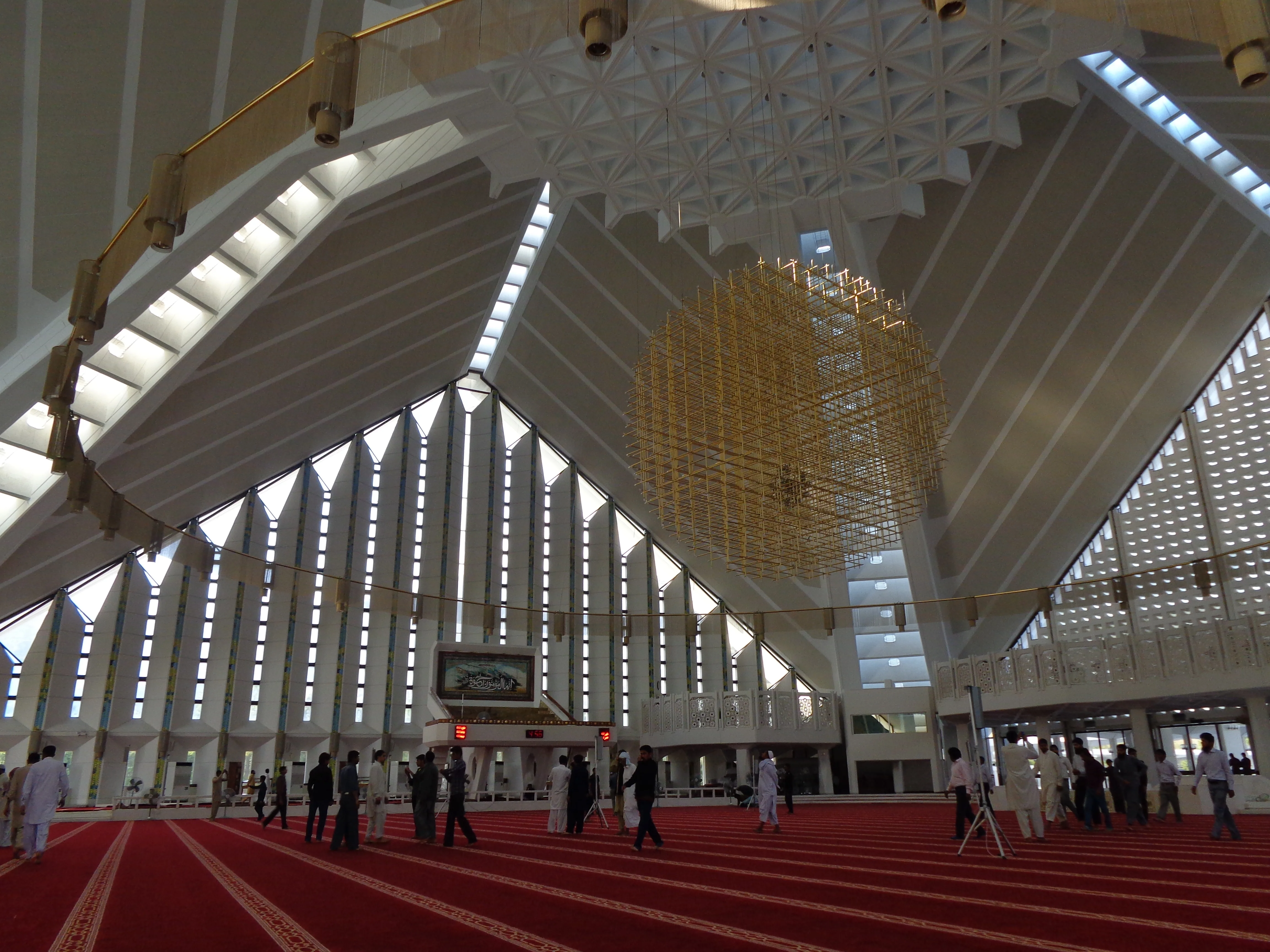 Interior of Faisal Mosque Islamabad, modern architecture with geometric design and chandeliers.