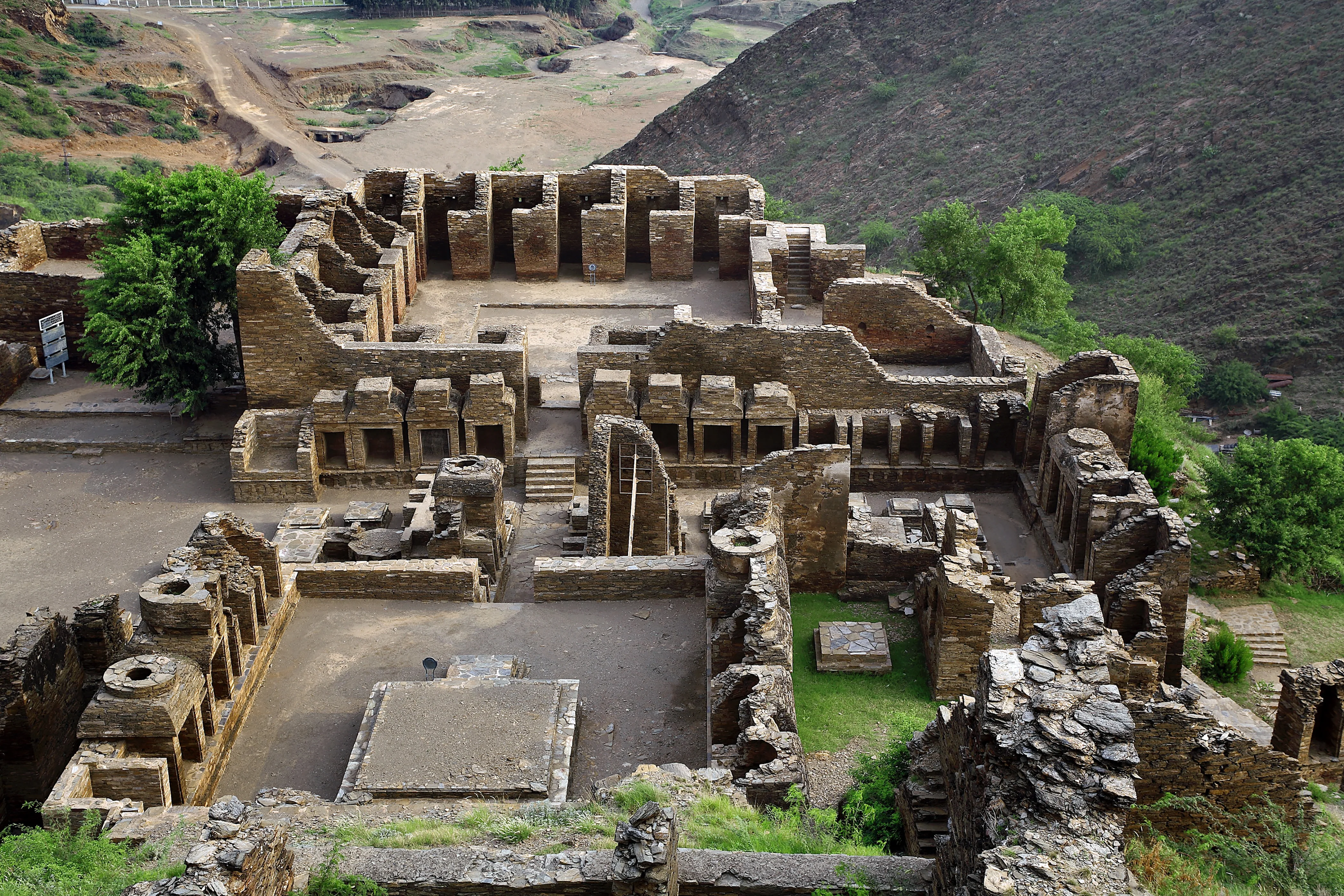 Takht-i-Bahi Buddhist monastery ruins in Pakistan, ancient stone structures on hill.