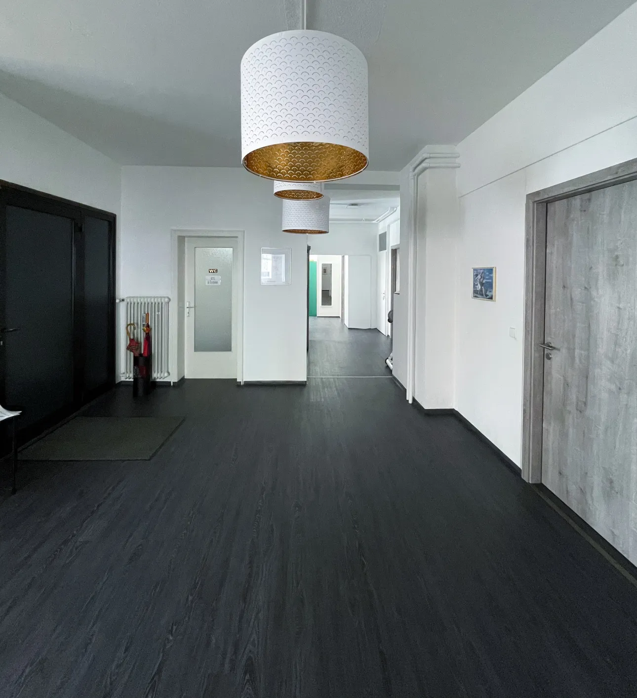 Ein großer, heller Flur mit einer Weißen Lampe im modernen Design.