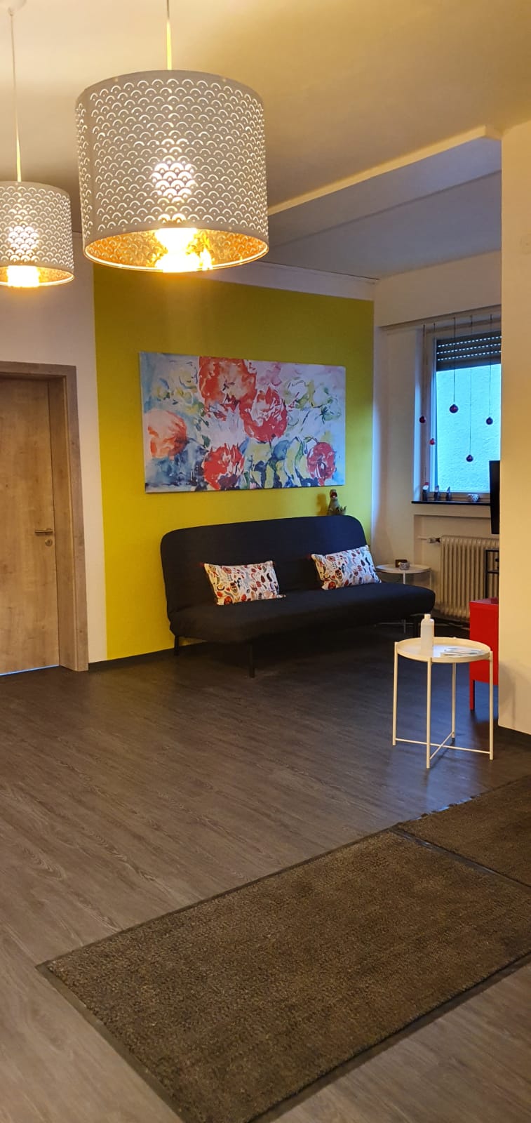 Ein Aufenthaltsraum mit gelben Wänden und einem Sofa mit Kissen