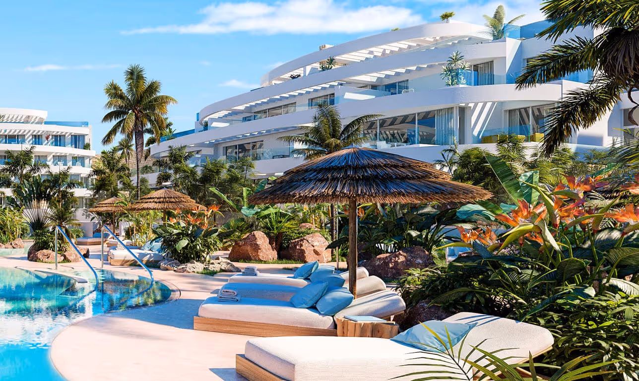 Luxusní resort s bazénem, lehátky a tropickou zahradou na Costa del Sol ve Španělsku.