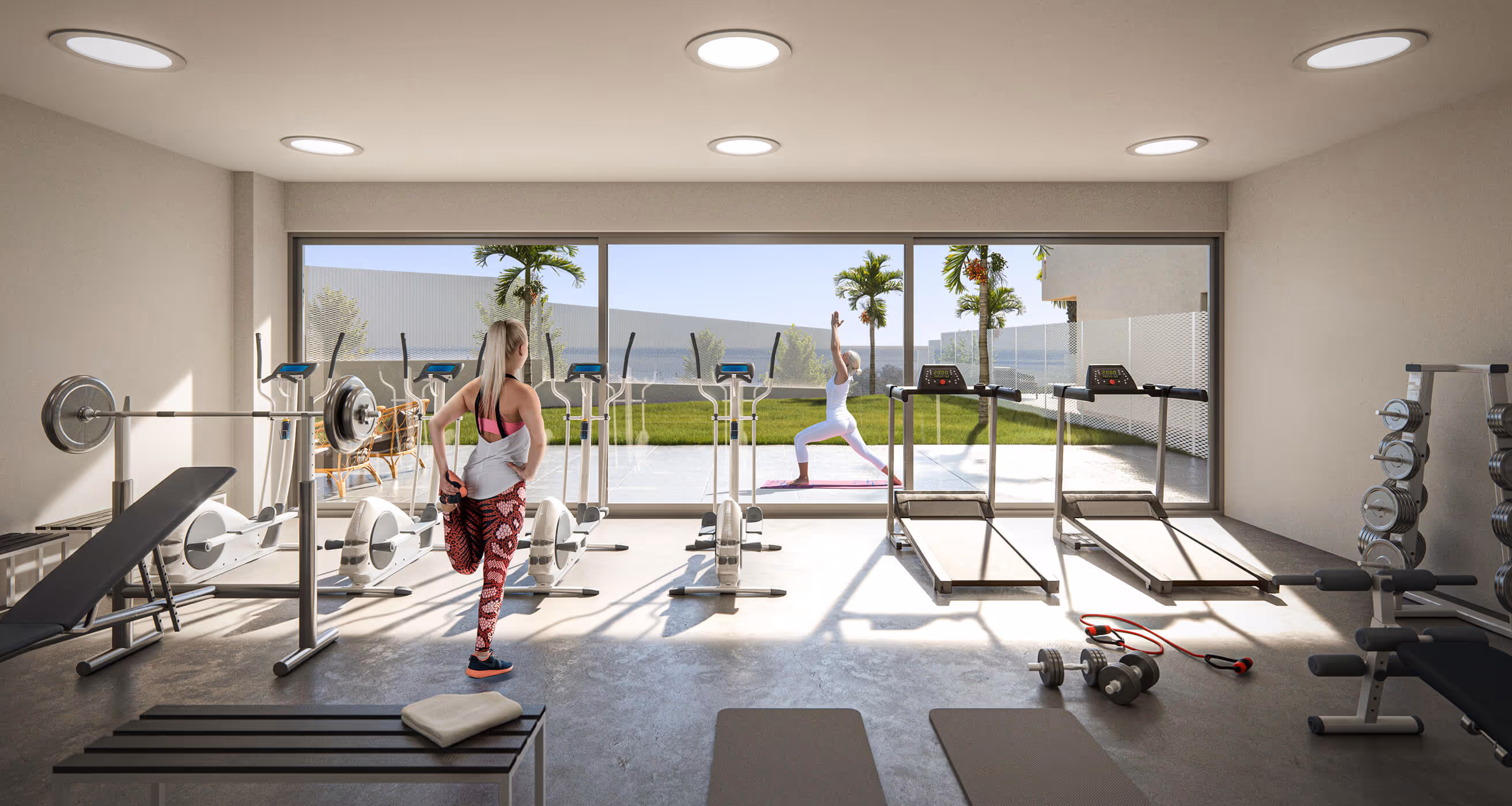 Moderní fitness centrum v luxusním resortu na Costa del Sol ve Španělsku s posilovacími stroji a výhledem do zahrady.