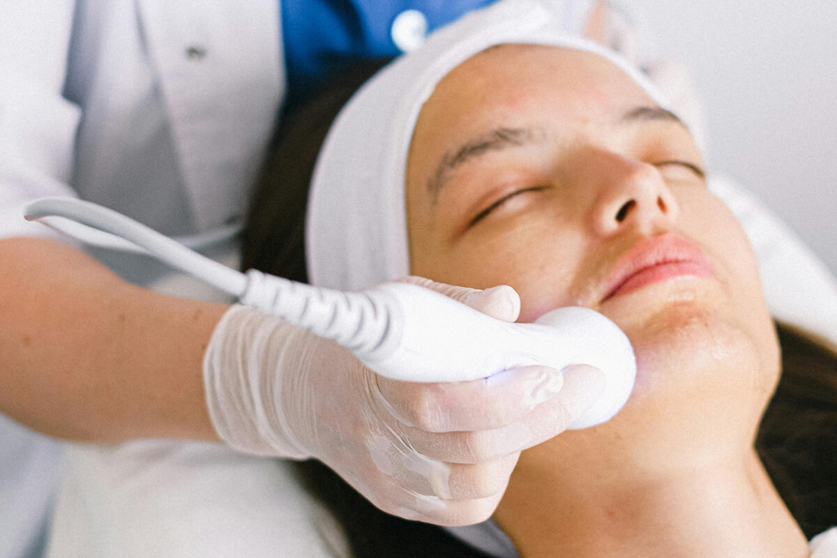 Frau bekommt Gesichtsanwendung mit technischem Gerät.