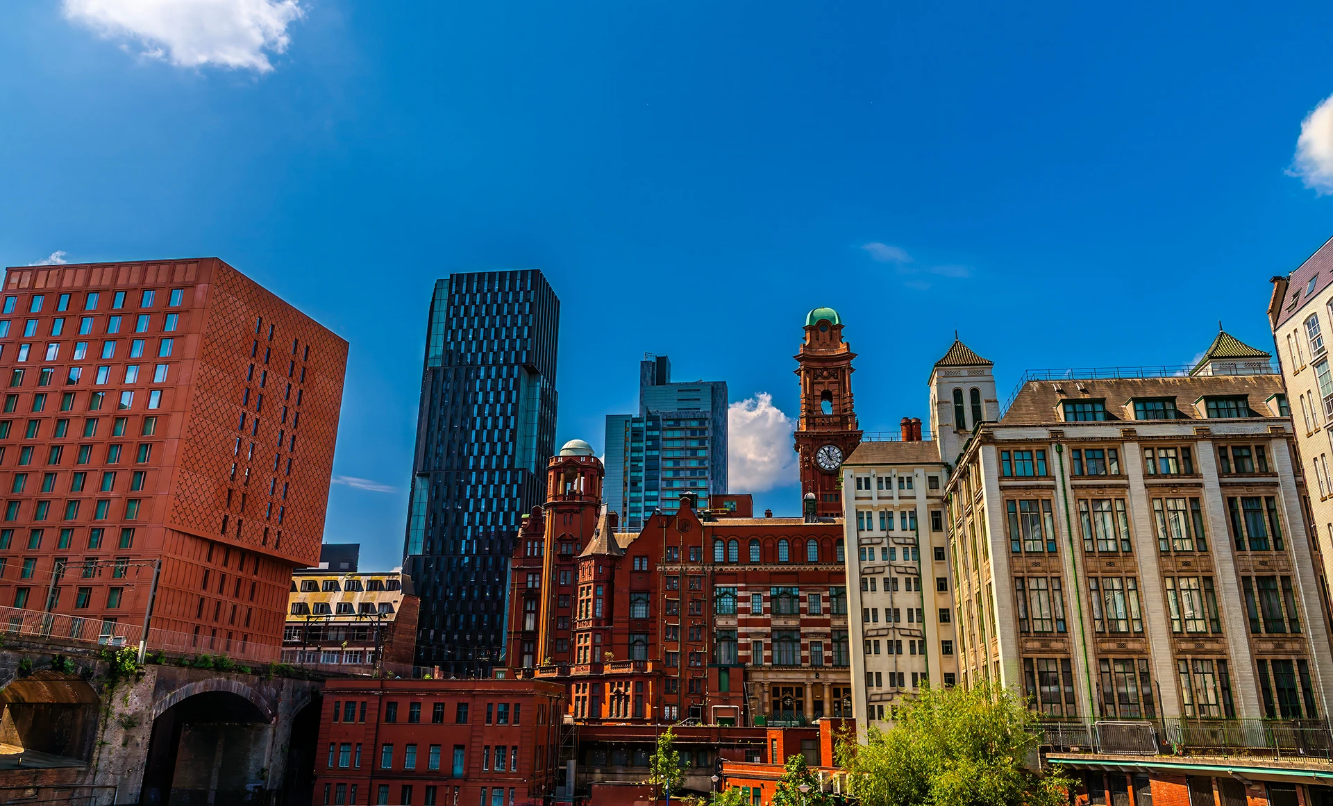 Manchester city center showing contrast between modern glass towers and historic red brick buildings