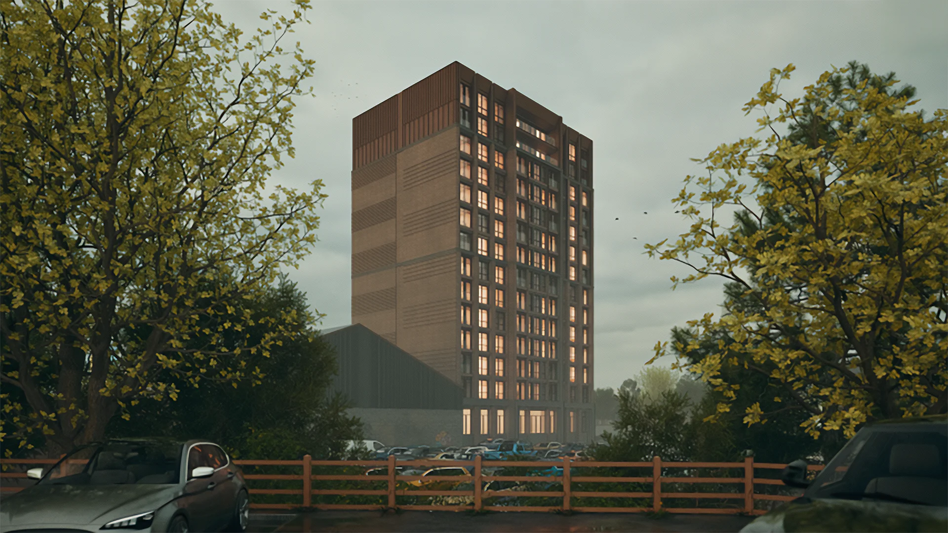 High-rise residential tower with bronze metal cladding and illuminated windows at dusk