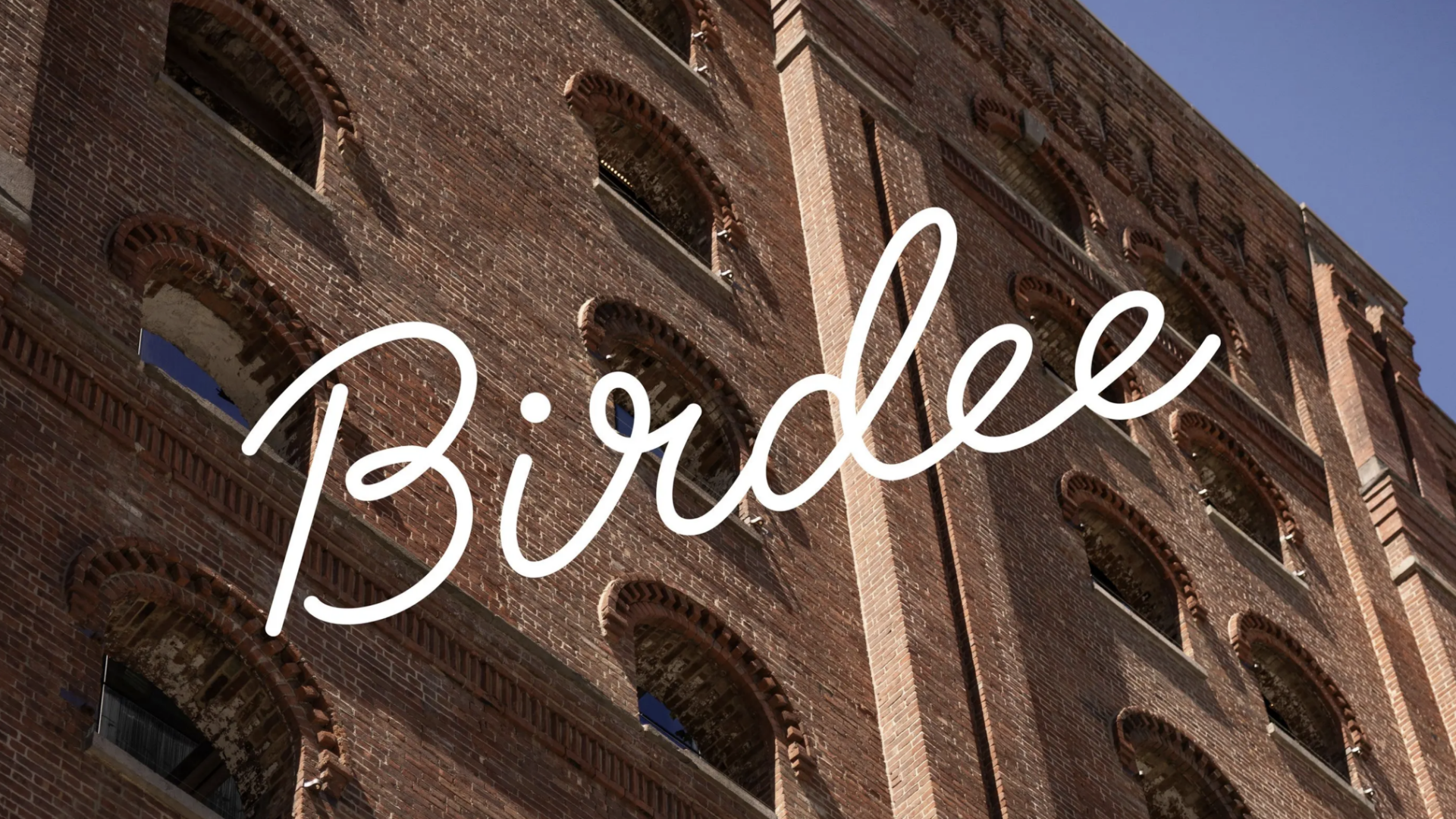 Birdee logo superimposed over city apartment building