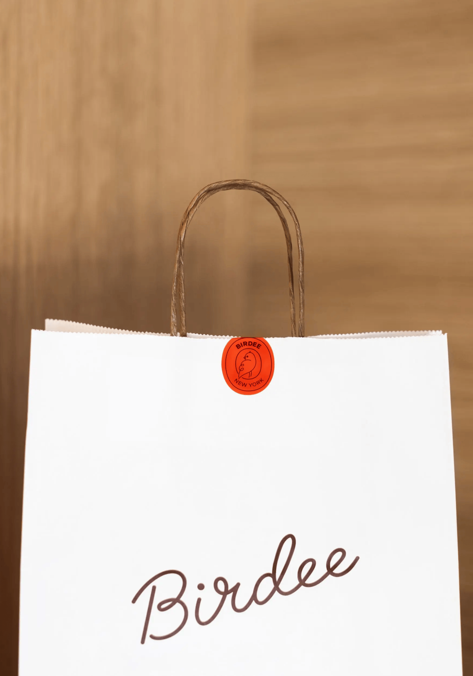 Birdee logo on white paper takeout bag